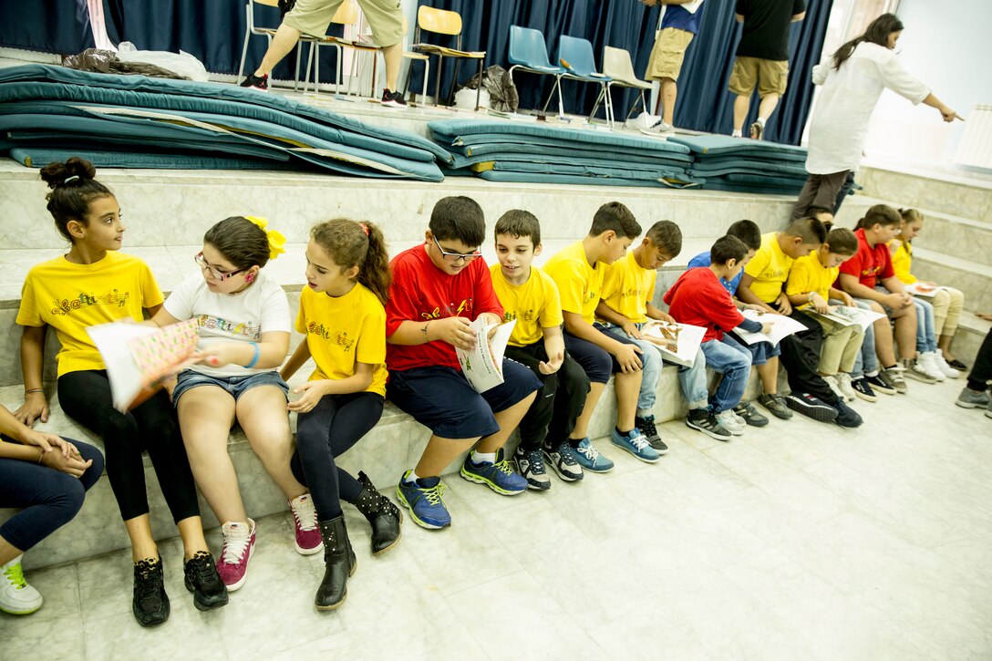 Students look through books that were donated to them by the Marines and Sailors of Special-Purpose Marine Air-Ground Task Force Africa 14 during a community relations event at a local elementary school, the Istituto Comprensivo Cesare Battisti of Catania, in the San Cristoforo neighborhood, Sept. 25, 2014. Service members with SP-MAGTF Africa read to the students, donated books, told them about themselves and got to know the individual children. (U.S. Marine Corps photo by Cpl. Shawn Valosin)