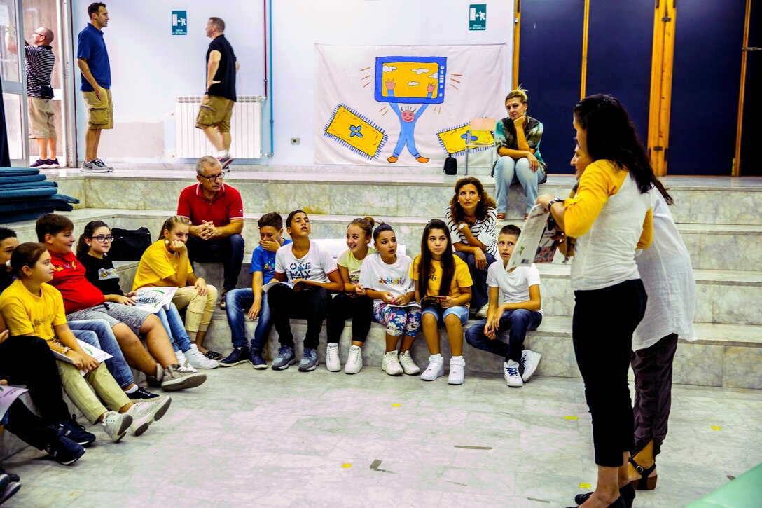 Sergeant Major Charmalyn Pile, the sergeant major of Special-Purpose Marine Air-Ground Task Force Africa 14, reads to students during a community relations event at a local elementary school, the at the Istituto Comprensivo Cesare Battisti of Catania, in the San Cristoforo neighborhood, Sept. 25, 2014. During the event service members with SP-MAGTF Africa read to the students, donated books, told them about themselves and got to know the individual children. (U.S. Marine Corps photo by Cpl. Shawn Valosin)