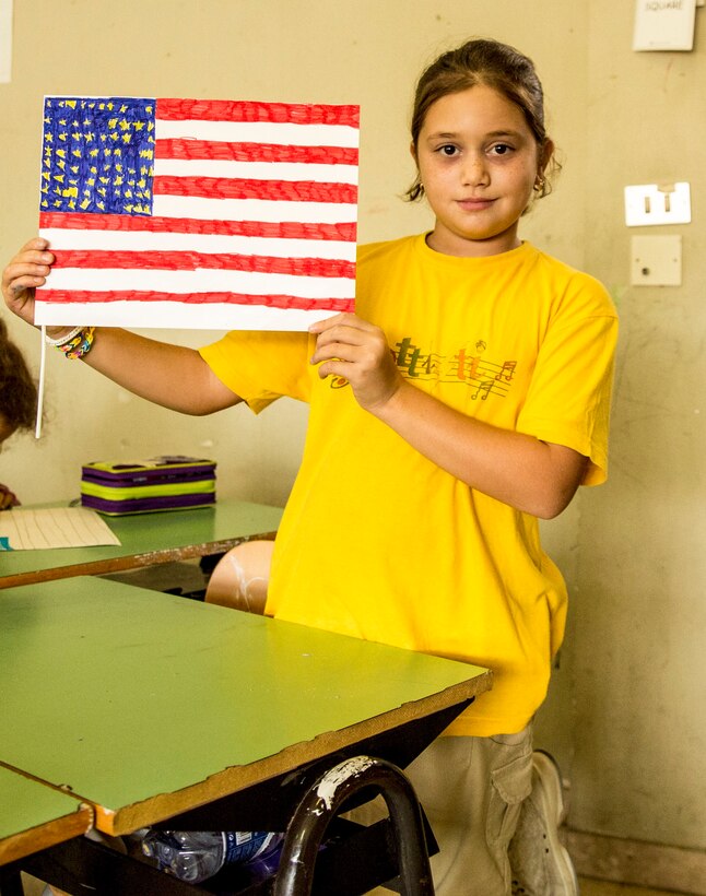 A student displays an American flag that she made during a community relations event at a local elementary school, the Istituto Comprensivo Cesare Battisti of Catania, in the San Cristoforo neighborhood, Sept. 25, 2014. The students and staff welcomed the service members from Naval Air Station Sigonella with a warm embrace, holding up handmade signs with American and Italian flags side-by-side. (U.S. Marine Corps photo by Cpl. Shawn Valosin)