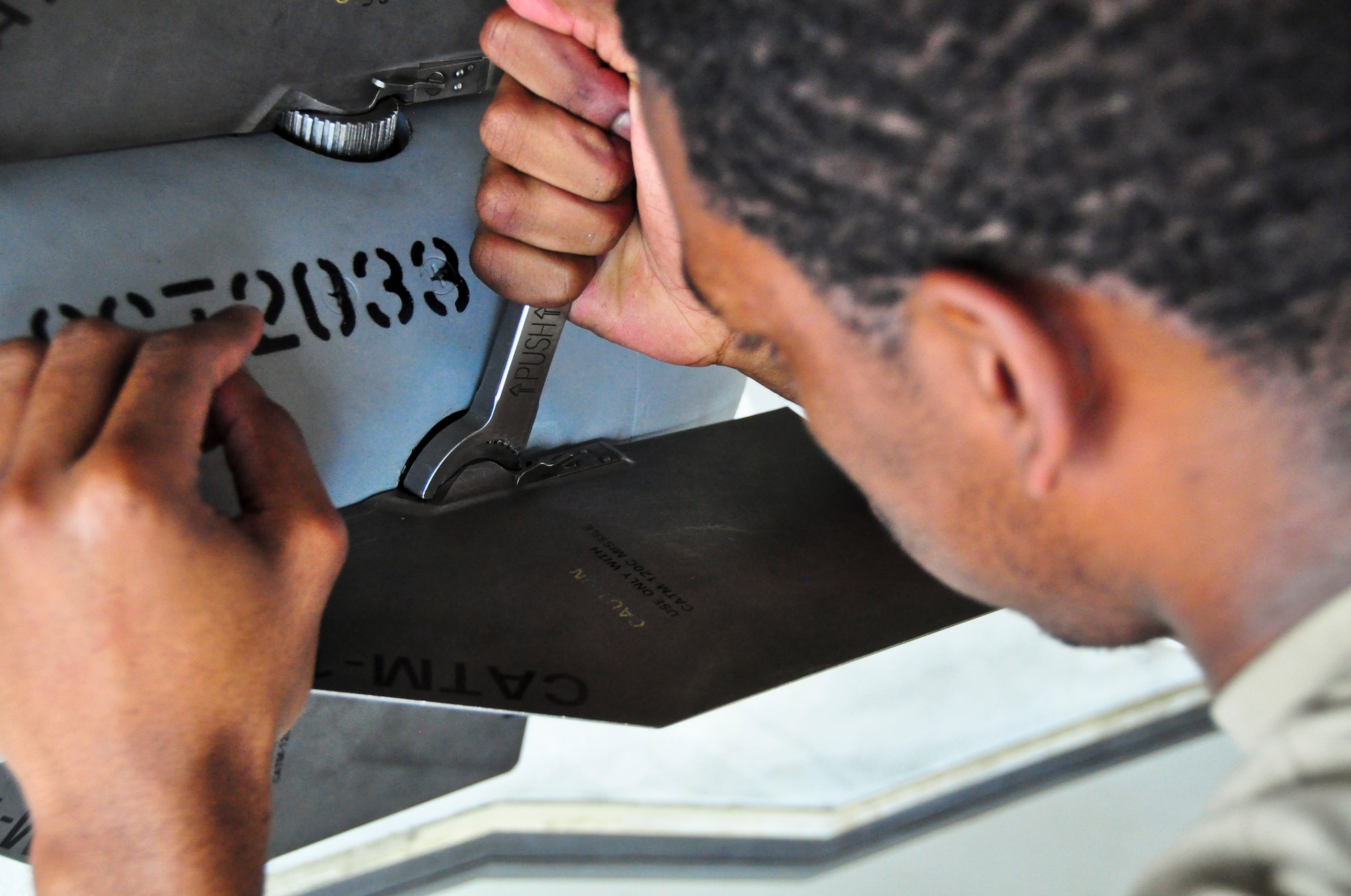 Airman 1st Class Robert Hughes puts the tail fins on to an AIM-120 advanced medium-range air-to-air missile after loading it on to an F-35A Lightning II during a qualification load Oct. 10, 2014, at Eglin Air Force Base, Fla. The F-35 training program at Eglin AFB currently serves as the primary source of F-35 expertise to new F-35A units across the Air Force. The newly qualified crewmembers will continue to hone their skills and become experts at their jobs so they can go train the weapons load crews at those bases receiving the F-35A. Hughes is a load crewmember from the 58th Aircraft Maintenance Unit crew one. (U.S. Air Force photo/Staff Sgt. Marleah Robertson)