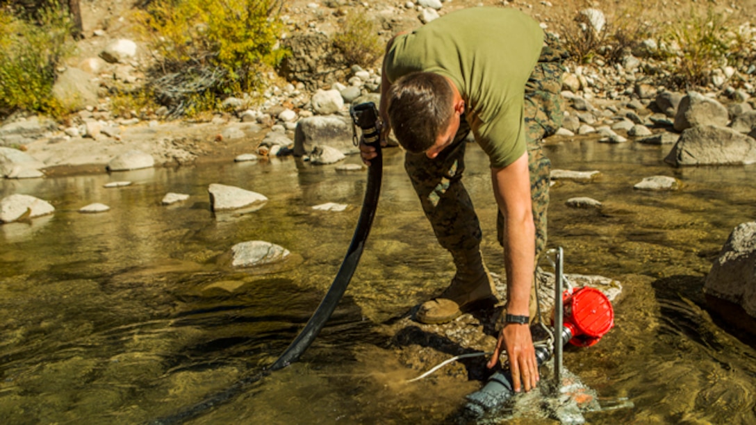 U.S. Marine Corps Lance Cpl. Michael R. Holmes, a water support technicians with Headquarters and Service Company, Combat Logistics Battalion 6, 2nd Marine Logistics Group, purifies river water using the Lightweight Water Purification System at Mountain Warfare Training Center, Bridgeport, California, October 20, 2014. CLB-6 stayed at MWTC to attend the basic mobility course and to provide logistical support to 2nd Battalion 5th Marine Regiment, 1st Marine Division. (U.S. Marine Corps photo by Cpl. Desire M. Mora/ Released)