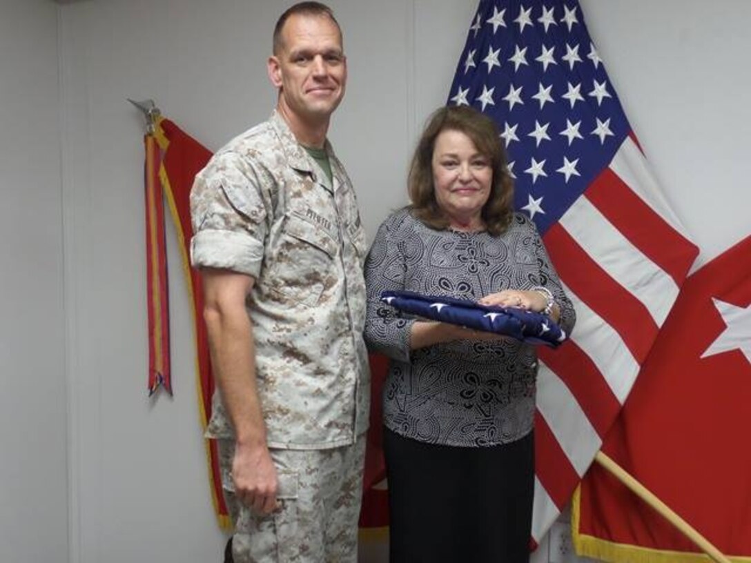 Ms. Purdy's recieves a US flag in recogniition of her 30 years of government service to the Marine Corps.