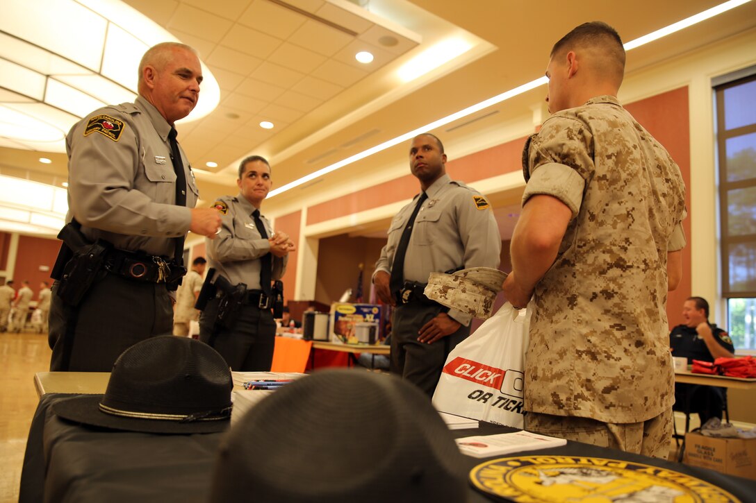 A Marine with II Marine Expeditionary Force speaks with North Carolina Highway Patrolmen during the II MEF Safety Expo at Marine Corps Base Camp Lejeune, N.C., Oct. 22, 2014. More than 20 local, state and federal organizations from across the nation set up tables to provide unique information on a wide array of safety subjects. Over the seven-hour period the event was open, approximately 1,500 Marines and sailors took time away from their work schedules to attend the expo.  (U.S. Marine Corps photo by Sgt. Paul Robbins Jr. / Released)
