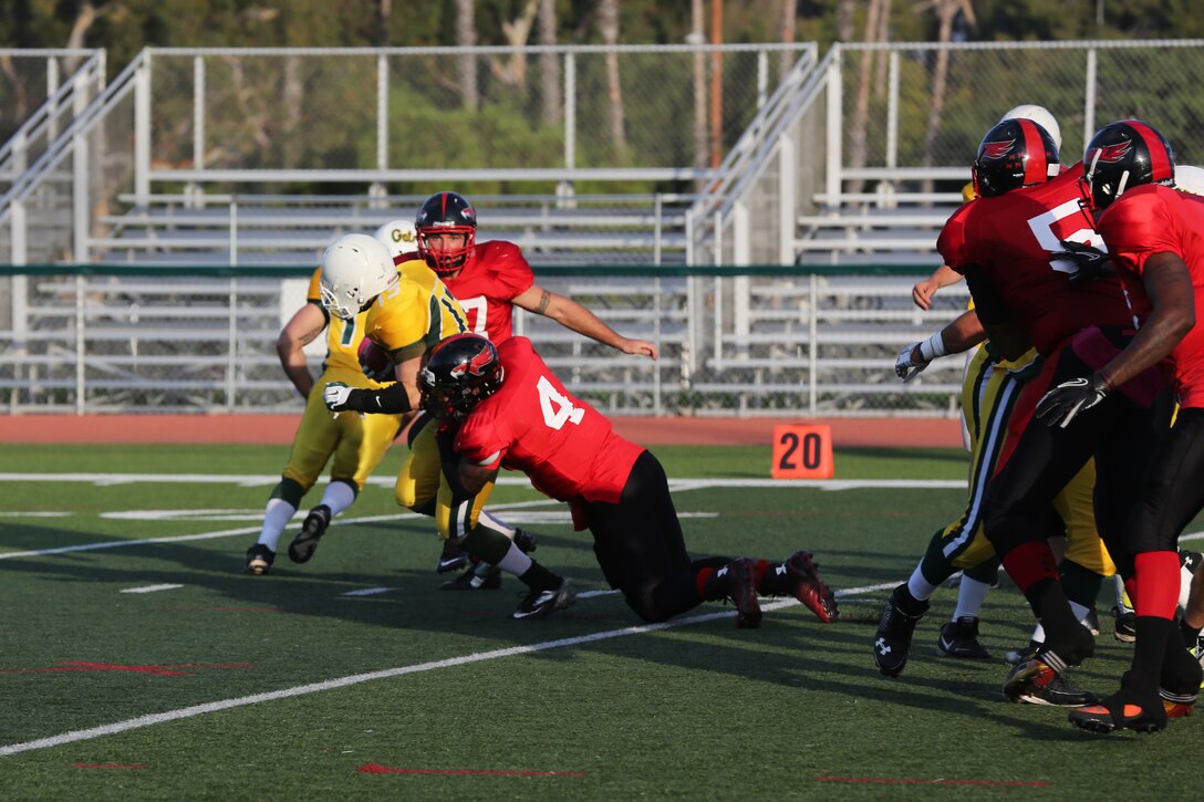 Stephen Scott, Marine Corps Air Station Miramar Falcons’ defensive back, drags down the 3rd Amphibian Assault Battalion Gators’ quarterback during a football game at Paige Fieldhouse aboard Marine Corps Base Camp Pendleton, Calif., Oct. 21. The Falcons defeated the Gators 30-0 eliminating the Gators from the playoffs.