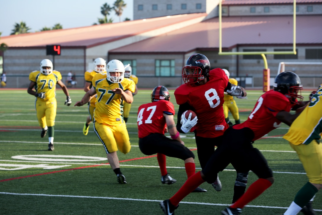 Dwayne Bracy, Marine Corps Air Station Miramar Falcons’ punt returner, dodges defenders during a game at Paige Fieldhouse aboard Marine Corps Base Camp Pendleton, Calif., Oct. 21. The Falcons eliminated the Gators from the playoffs with a 30-0 win.