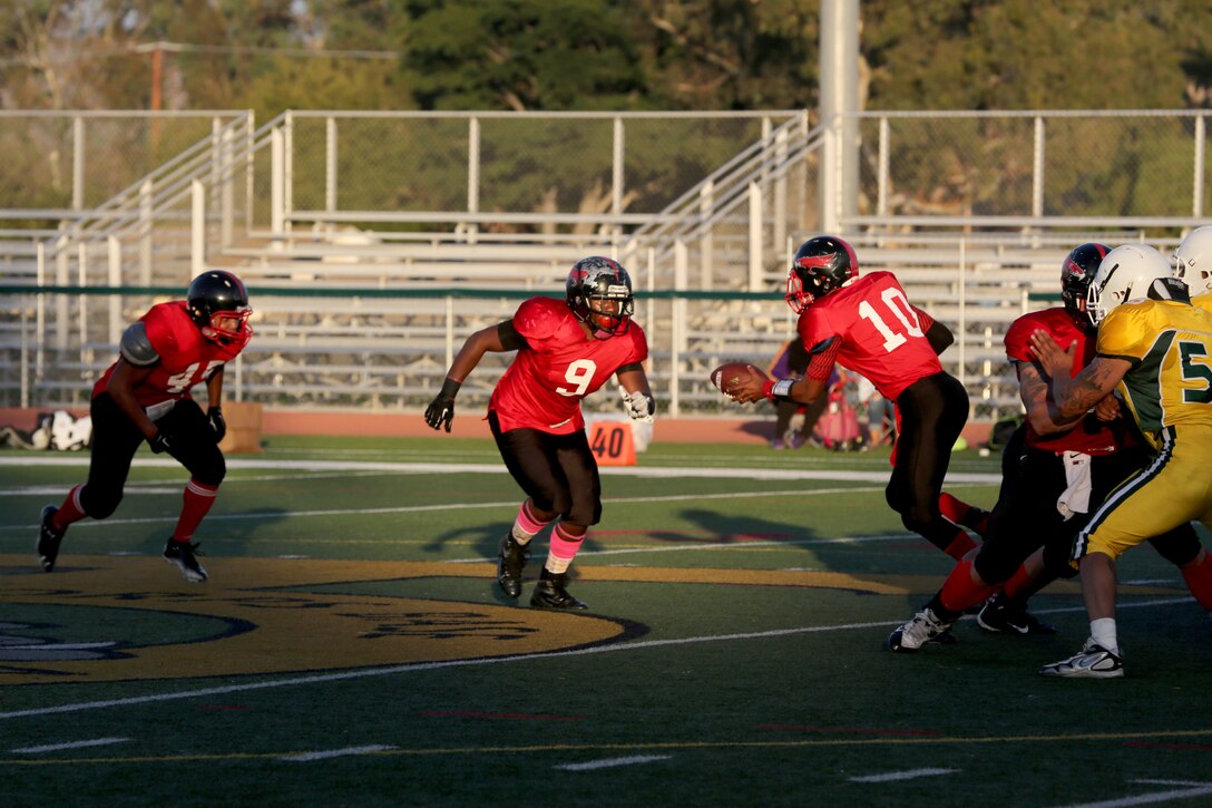 Jabari Moore, Marine Corps Air Station Miramar Falcons’ quarterback attempts to hand the football to Leo Briggs, Falcons’ running back, during a football game at Paige Fieldhouse aboard Marine Corps Base Camp Pendleton, Calif., Oct. 21. The Falcons advanced in the playoffs with the 30-0 win over the Gators. 