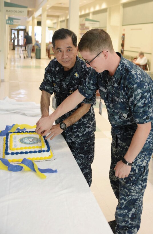 In commemoration of the U.S. Navy’s 239th birthday, personnel at the Naval Branch Health Clinic Albany, Marine Corps Logistics Base Albany, celebrate with their traditional cake-cutting ceremony, Oct. 15. Cmdr. Michael Tai, the oldest, and Hospitalman Wesley Balentine, the youngest, sailors at the clinic cut the cake and shared the first slice. Lt. Cmdr. Raymond Bristol, officer-in-charge, narrated the purpose of the sharing of the cake between the two as a metaphoric passing of knowledge from the senior down to the junior sailors.