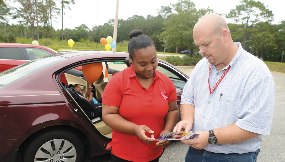 William Womble, traffic safety program manager, Risk Management,  Marine Corps Logistics Base Albany, reviews safety requirements with parent Adrianna Butler. The car seat safety check held recently at the installation's Child Development Center, marked the second year for the event.