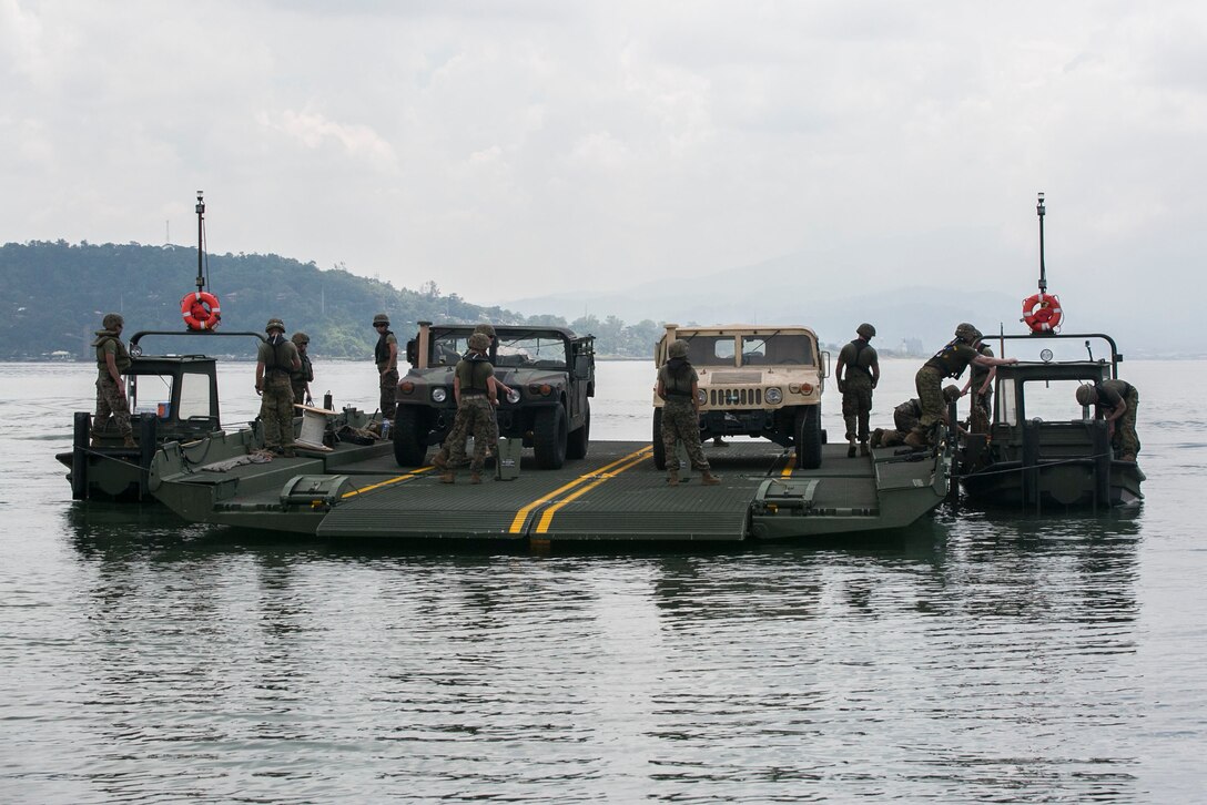 U.S. Marines participating in T-AKE 14-2 transport Humvees using components of an Improved Ribbon Bridge pushed by Bridge Erection Boats while executing ship-to-shore transport operations Sept. 24 in logistical support of Amphibious Landing Exercise 2015 in Subic Bay, Philippines. The operation proved the concept that IRB components can be used in conjunction with BEBs on the open ocean as a ship-to-shore connector for transporting supplies and equipment to Marines on shore. PHIBLEX is an annual bilateral training exercise conducted by the Armed Forces of the Philippines alongside U.S. Marine and Navy forces. The Marines are combat engineers with 9th Engineer Support Battalion, 3rd Marine Logistics Group, III Marine Expeditionary Force, currently assigned to Combat Logistics Detachment 379, Headquarters Regiment, 3rd MLG, III MEF. T-AKE 14-2 is a maritime pre-positioned force, multi-country theater security cooperation event that deployed from Okinawa aboard the USNS Sacagawea to participate in training exercises throughout the Asia-Pacific area of operations. (U.S. Marine Corps photo by Cpl. Drew Tech/Released)