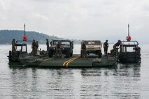 U.S. Marines participating in T-AKE 14-2 transport Humvees using components of an Improved Ribbon Bridge pushed by Bridge Erection Boats while executing ship-to-shore transport operations Sept. 24 in logistical support of Amphibious Landing Exercise 2015 in Subic Bay, Philippines. The operation proved the concept that IRB components can be used in conjunction with BEBs on the open ocean as a ship-to-shore connector for transporting supplies and equipment to Marines on shore. PHIBLEX is an annual bilateral training exercise conducted by the Armed Forces of the Philippines alongside U.S. Marine and Navy forces. The Marines are combat engineers with 9th Engineer Support Battalion, 3rd Marine Logistics Group, III Marine Expeditionary Force, currently assigned to Combat Logistics Detachment 379, Headquarters Regiment, 3rd MLG, III MEF. T-AKE 14-2 is a maritime pre-positioned force, multi-country theater security cooperation event that deployed from Okinawa aboard the USNS Sacagawea to participate in training exercises throughout the Asia-Pacific area of operations. (U.S. Marine Corps photo by Cpl. Drew Tech/Released)
