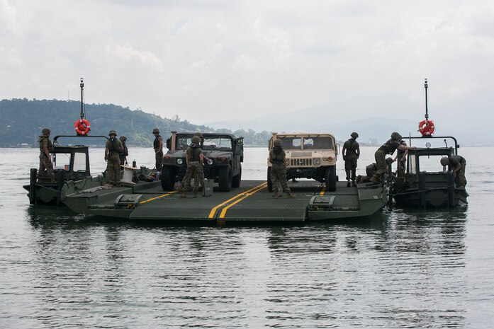 U.S. Marines participating in T-AKE 14-2 transport Humvees using components of an Improved Ribbon Bridge pushed by Bridge Erection Boats while executing ship-to-shore transport operations Sept. 24 in logistical support of Amphibious Landing Exercise 2015 in Subic Bay, Philippines. The operation proved the concept that IRB components can be used in conjunction with BEBs on the open ocean as a ship-to-shore connector for transporting supplies and equipment to Marines on shore. PHIBLEX is an annual bilateral training exercise conducted by the Armed Forces of the Philippines alongside U.S. Marine and Navy forces. The Marines are combat engineers with 9th Engineer Support Battalion, 3rd Marine Logistics Group, III Marine Expeditionary Force, currently assigned to Combat Logistics Detachment 379, Headquarters Regiment, 3rd MLG, III MEF. T-AKE 14-2 is a maritime pre-positioned force, multi-country theater security cooperation event that deployed from Okinawa aboard the USNS Sacagawea to participate in training exercises throughout the Asia-Pacific area of operations. (U.S. Marine Corps photo by Cpl. Drew Tech/Released)