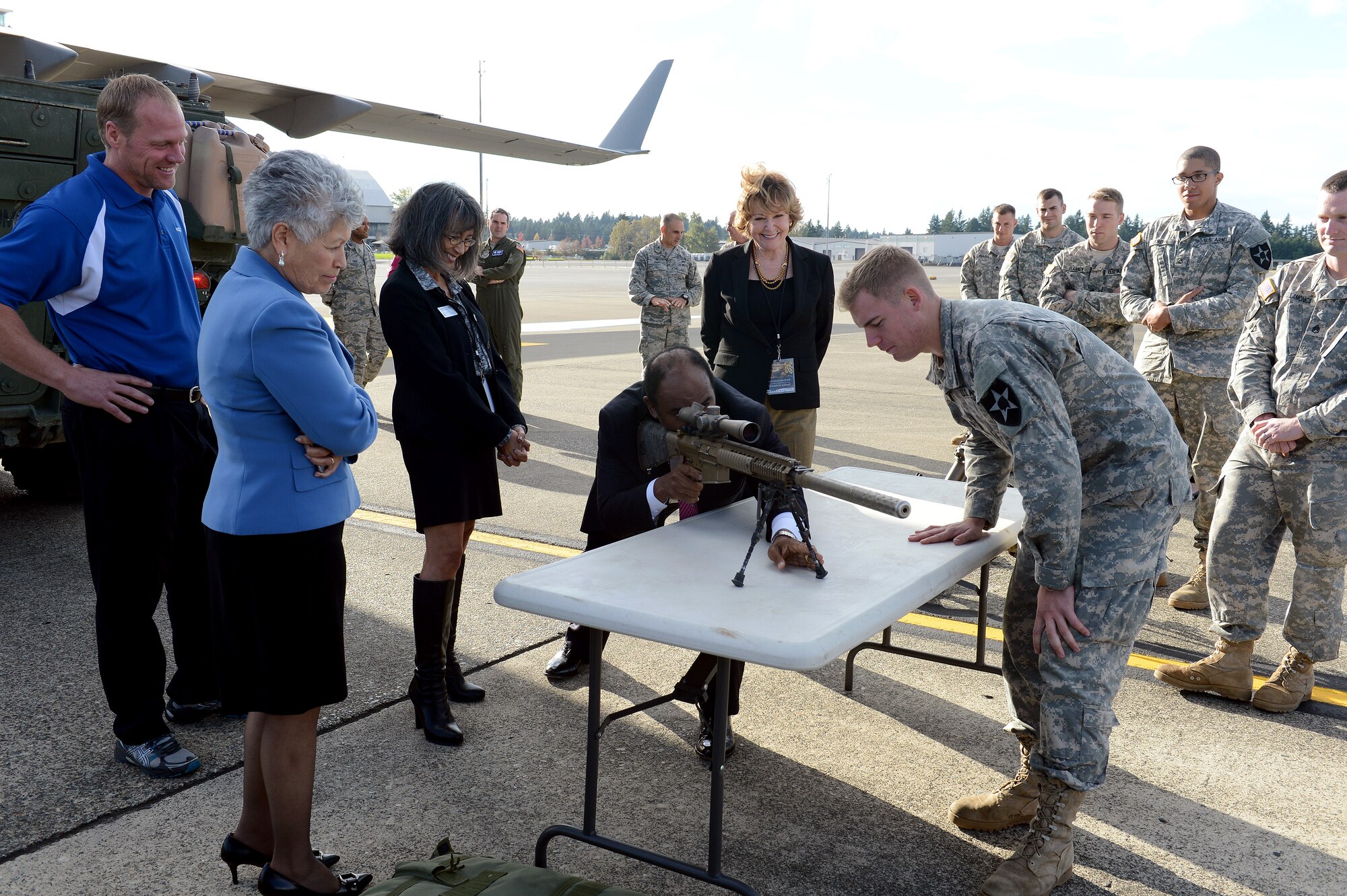 Spc. Clayton Wilson (right), Cherokee Company 4th Battalion 423rd Infantry Regiment sniper, explains to the guests how  a sniper rifle is used Oct. 21, 2014, during the Joint Base Lewis-McChord Service Member for Life Transition Summit at JBLM, Wash. The tour group was able to look around several vehicles and equipment, along with the C-17 Globemaster III, to learn their functions and roles during missions. (U.S. Air Force photo/Airman 1st Class Keoni Chavarria)