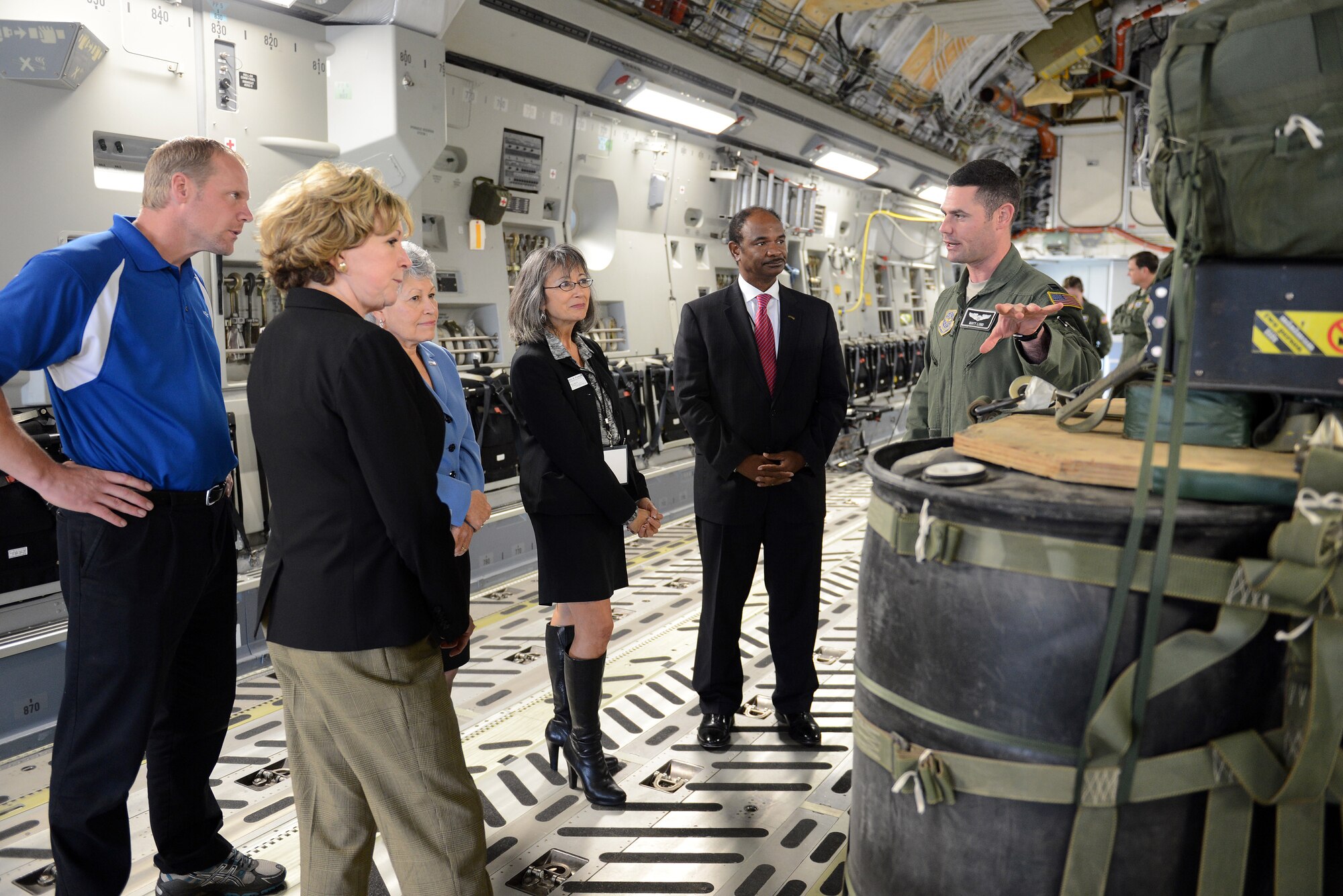 Capt. Matthew Lund (right), 62nd Operations Support Squadron deputy director of wing tactics, explains the joint precision air drop system to visitors of the Joint Base Lewis-McChord Service Member for Life Transition Summit Oct. 21, 2014, at JBLM, Wash. During the tour, the visitors learned the importance of the military utilizing its resources efficiently and effectively. (U.S. Air Force photo/Airman 1st Class Keoni Chavarria)