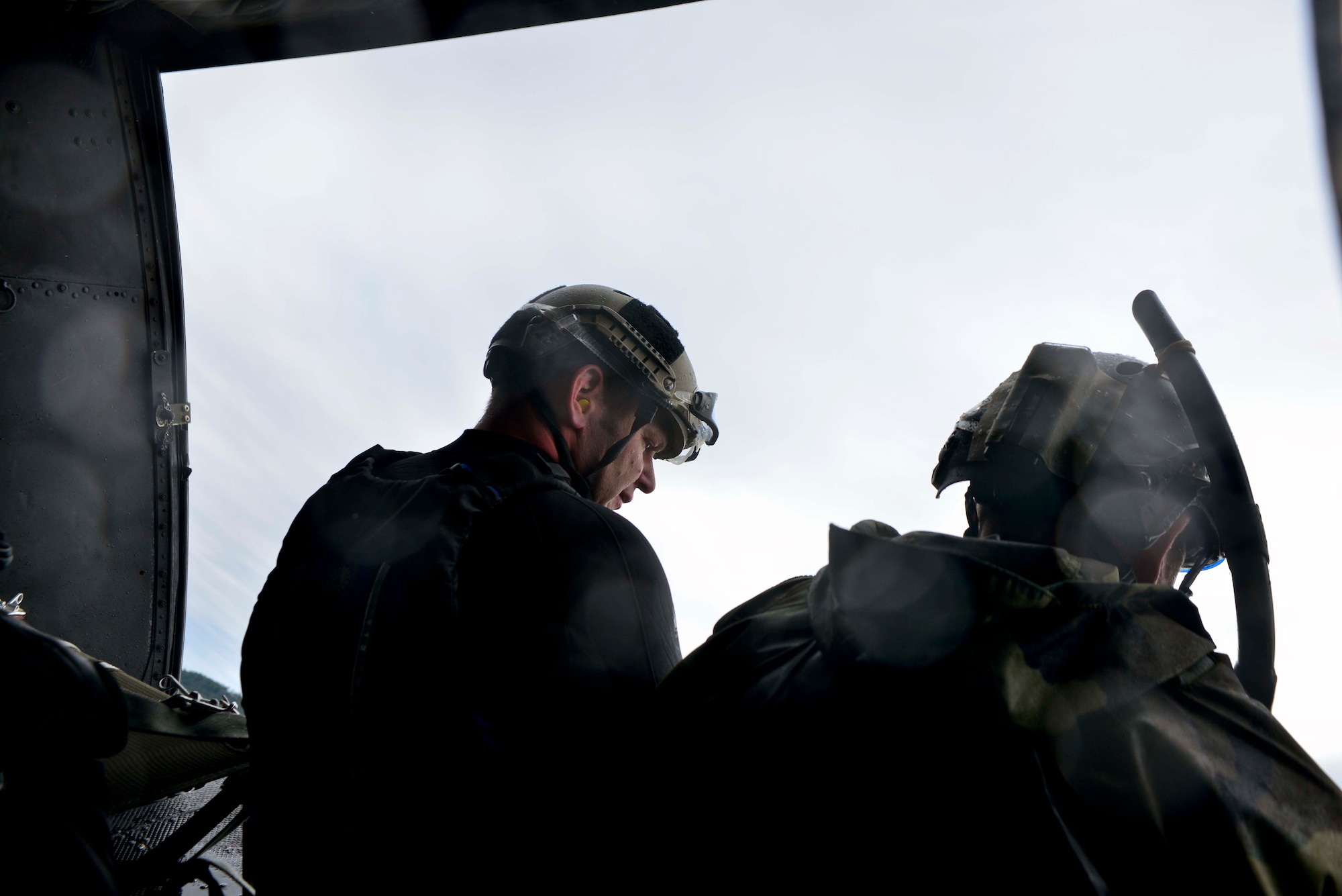 Capt. Marcus Truman, 336th Training Group combat rescue officer, looks out the bay door of a UH-1N Iroquois helicopter during a water operations training scenario Oct. 17, 2014, at Long Lake, Washington. The training was also conducted to help train new helicopter pilots and aircrew assigned to the 36th Rescue Flight with maneuvering and retracting persons from water situations. Without a full survivor scenario, the focus was on the initial training of new pilots and the recertification of aircrew members with the 36th Rescue Flight.  (U.S. Air Force photo/Staff Sgt. Alexandre Montes)
