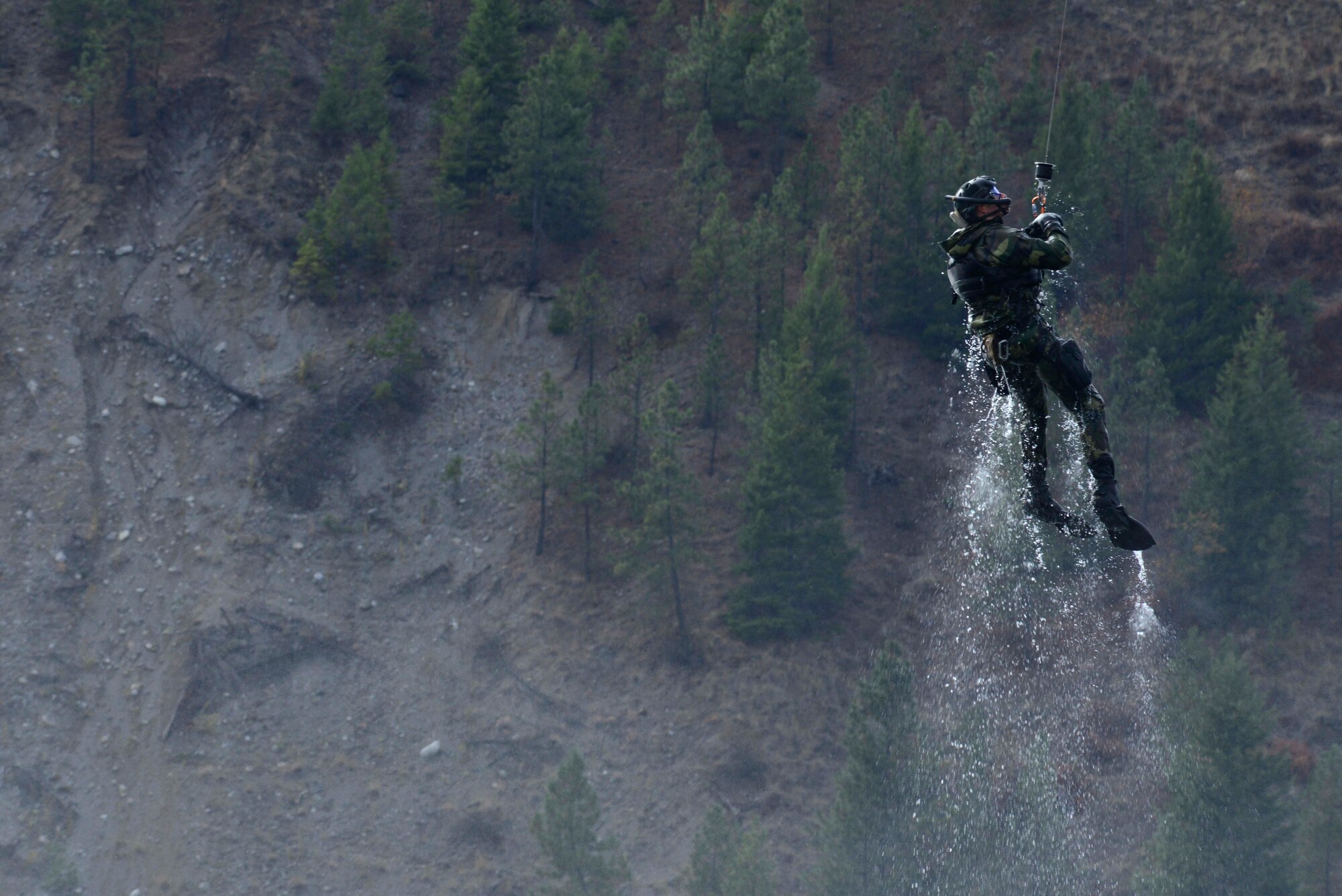 Capt. Matthew Arnold, 66th Training Squadron combat rescue officer, is hoisted onto a UH-1N Iroquois helicopter from the 36th Rescue Flight during a water operations training scenario Oct. 17, 2014, at Long Lake, Washington. Combat rescue officer, or CRO, is a career field that was created to strengthen Air Force personnel recovery capabilities. The CRO specialty includes direct combatant command and control of combat search and rescue operations. CRO’s and aircrews also train to perform these iterations in rough seas where a rescue hoist is not possible due to wave action.  In that instance, they must calculate their jump from the aircraft to land at the top of the wave to avoid freefalling too far and injuring themselves while entering the water.  All of this requires constant communication with the entire aircrew and practice. (U.S. Air Force photo/Staff Sgt. Alexandre Montes)