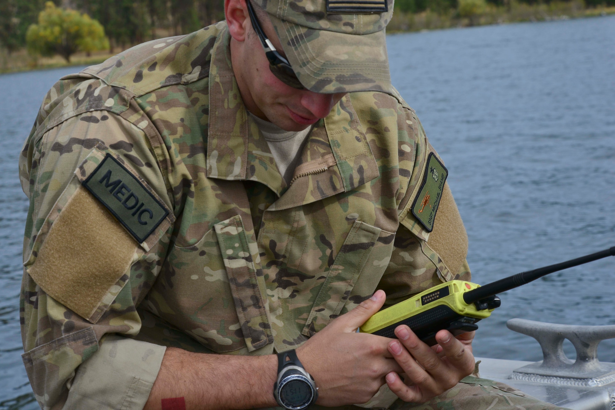 Staff Sgt. Micahel Shamp, 336th Training Support Squadron independent duty medical technician listens for the 'all clear' during water operations training from pilots aboard a UH-1N Iroquois helicopter assigned to the 36th Rescue Flight Oct. 17, 2014, at Long Lake, Washington. . Shamp, accompanied by another independent duty medical technician, Staff Sgt. Brittany Scott, were on standby on a boat to ensure maximum safety before, during and after the water operations training. As an independent duty medical technician they are the sole medical providers in case of an emergency at a moment’s notice. (U.S. Air Force photo/Staff Sgt. Alexandre Montes)