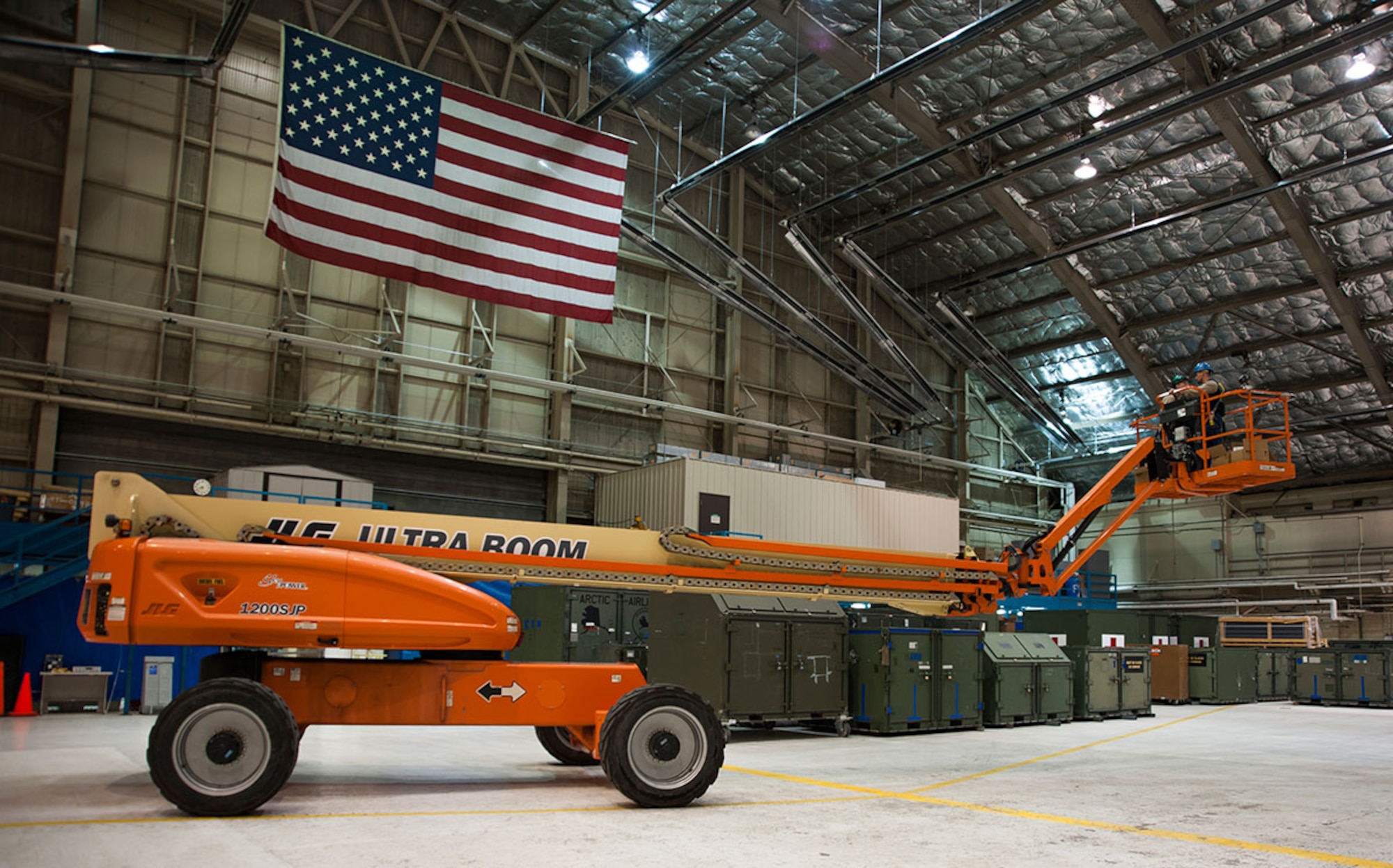 Preston Murfin and Raymond Clarke prepare to change high-intensity discharge lights in Hangar 3 on Joint Base Elmendorf-Richardson, Alaska, Oct. 21, 2014. They operate a 120-foot boom lift to change the lights in an easy and safe manner. Murfin and Clarke are electrical engineers from the 773d Civil Engineer Squadron. (U.S. Air Force photo/Airman 1st Class Tammie Ramsouer)