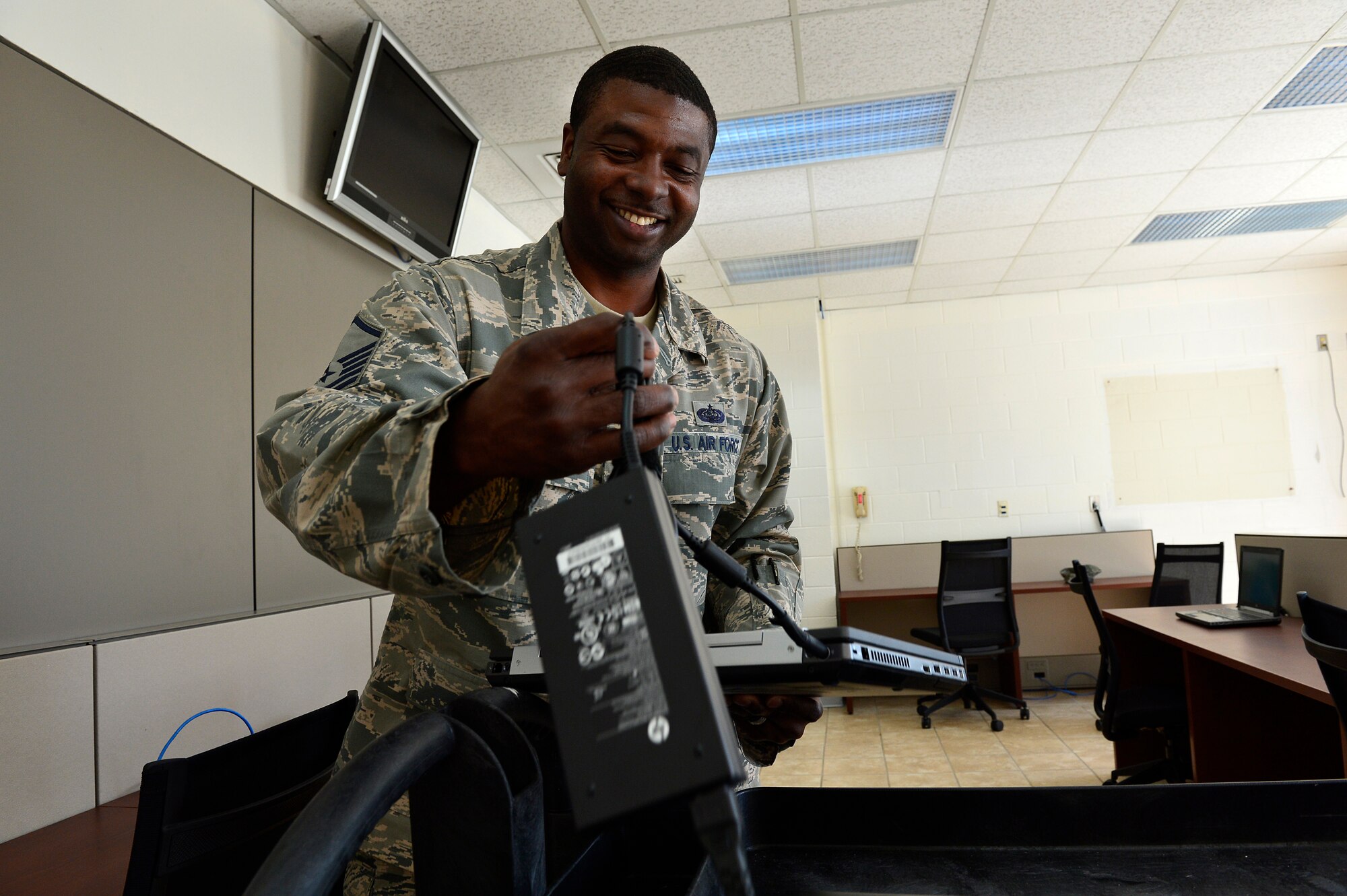 MCGHEE TYSON AIR NATIONAL GUARD BASE, Tenn. -- Master Sgt. Raymond Harris, Cyber Operations technician for the I.G. Brown Training and Education Center, installs laptop computers Oct. 22, 2014, here in the Morrisey Hall classroom building. The 21 computers as well as recently installed furniture are part of two  cyber cafes coming online near the downstairs entrances. (U.S. Air National Guard photo by Master Sgt. Mike R. Smith/Released) 