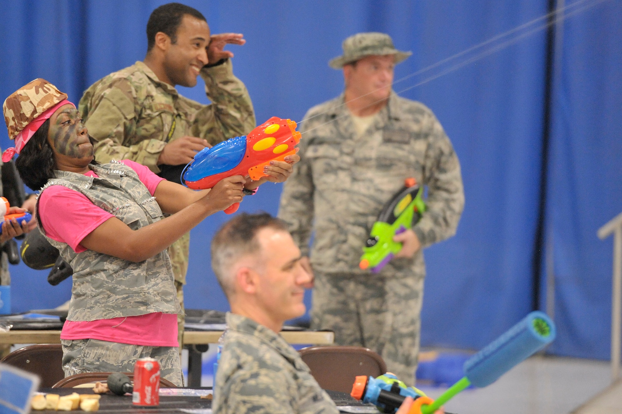 U.S. Air Force Staff Sgt. Hope Thomas, 31st Intelligence Squadron Detachment 1 geospatial intelligence analyst, fires her water gun during a water fight at the U.S. Air Forces Central intelligence directorate’s combat dining-in at Shaw Air Force Base, S.C., Oct. 10, 2014. The dining-in featured a dinner, water gun fight, and a gauntlet to the traditional Air Force grog bowl. (U.S. Air Force photo by Airman 1st Class Jonathan Bass/Released)