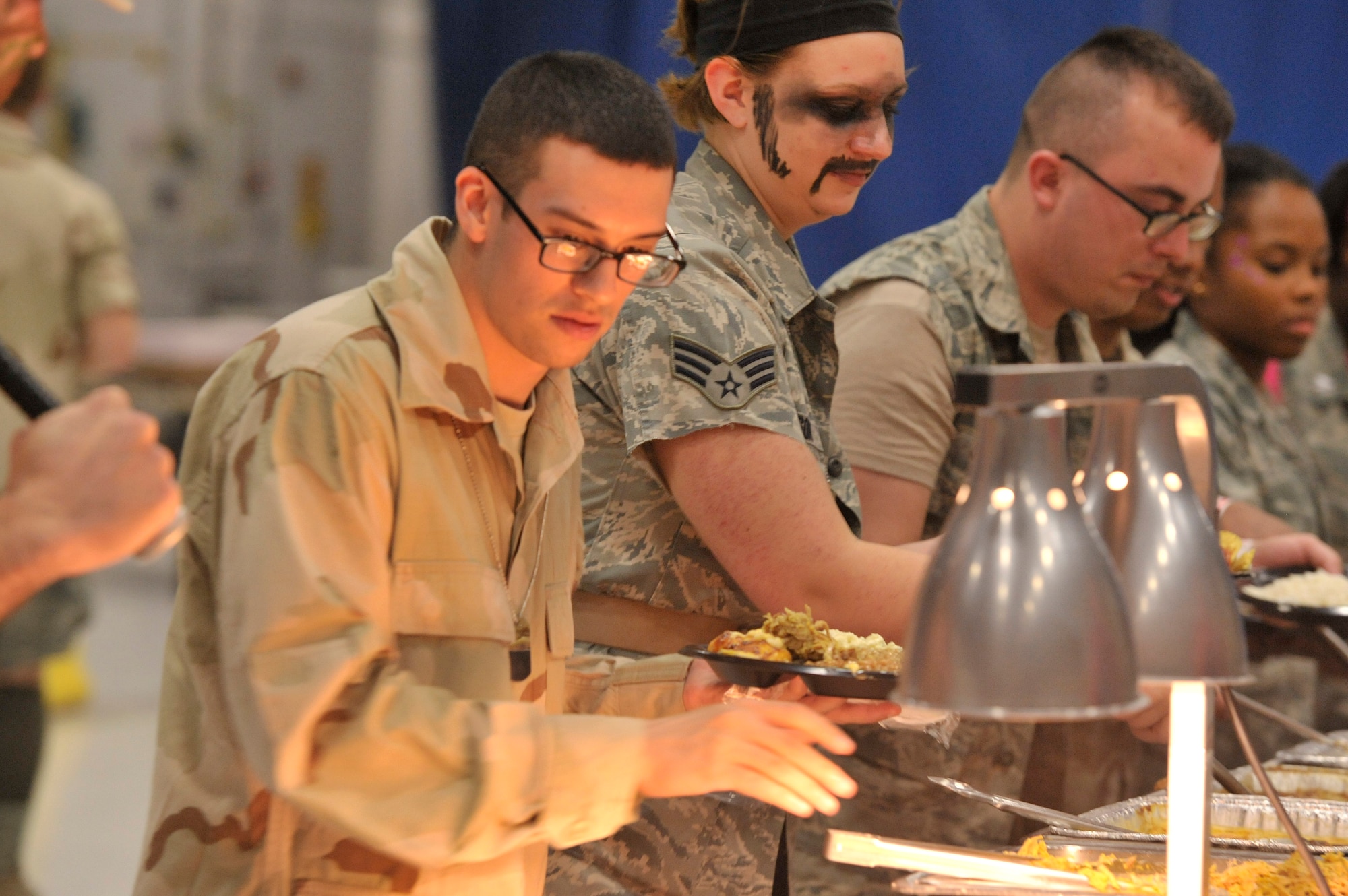 U.S. Air Force Airmen assigned to U.S. Air Forces Central intelligence directorate go through the dinner line during the AFCENT intelligence directorate’s combat dining-in at Shaw Air Force Base, S.C., Oct. 10, 2014. A combat dining-in is an informal dinner where Airmen get together for food, fun, and fellowship with Airmen from their work center. (U.S. Air Force photo by Airman 1st Class Jonathan Bass/Released)