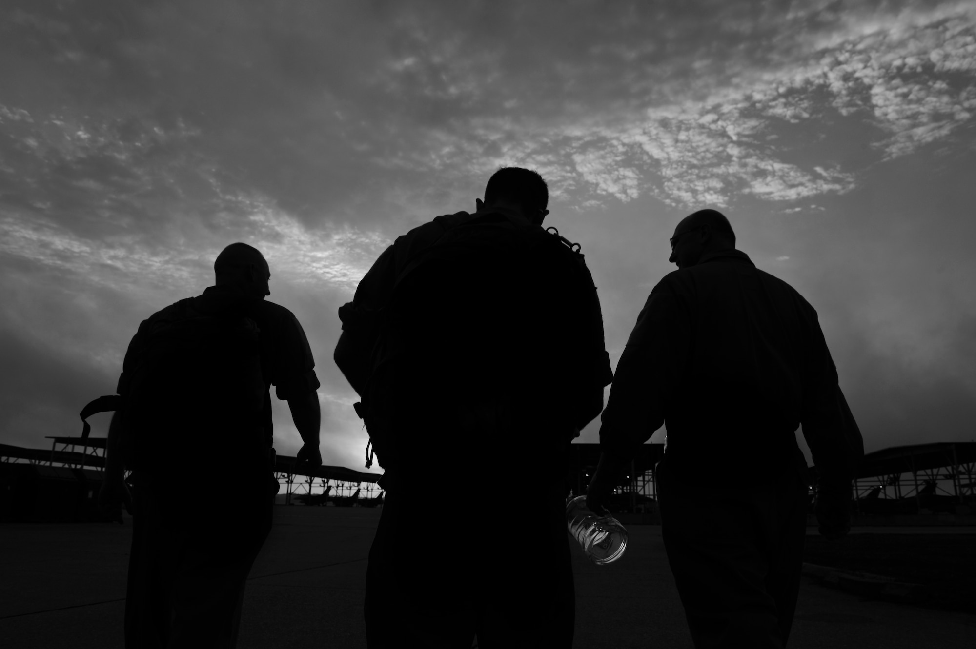 (From left) U.S. Air Force Senior Airman Matthew Leke, 20th Aircraft Maintenance Squadron tactical aircraft maintainer, Staff Sgt. Stephen Leonardi, 20th AMXS tactical aircraft maintainer, and Chief Master Sgt. Charles Mills, 20th Fighter Wing command chief, walk out to the flightline to receive a spare tire at Shaw Air Force Base, S.C., Oct. 14, 2014. Mills shadowed Leonardi to learn the daily duties of a crew chief. (U.S. Air Force photo by Senior Airman Tabatha Zarrella/Released)