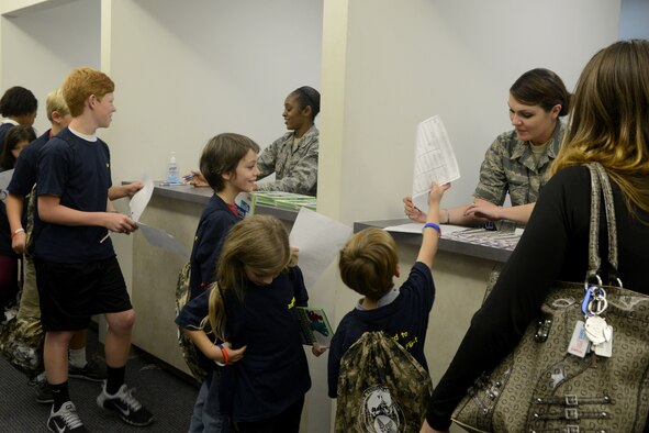 A row of children line up to receive simulated shots and paperwork during Operation Take Flight at Shaw Air Force Base, S.C., Oct. 16, 2014. The children were deployed to “Shawzakistan” after they were processed through the deployment line. (U.S. Air Force photo by Senior Airman Ashley L. Gardner/Released)