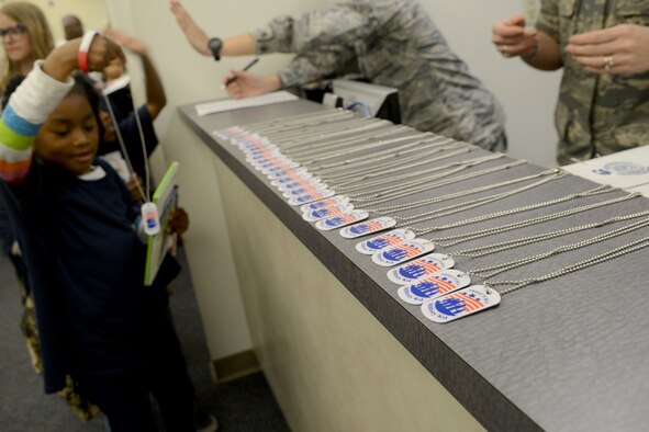Dog tags are given to junior deployers during Operation Take Flight at Shaw Air Force Base, S.C., Oct. 16, 2014. There were 329 deployers who had the opportunity to experience what their mom’s and dad’s do before deploying. (U.S. Air Force photo by Senior Airman Ashley L. Gardner/Released)