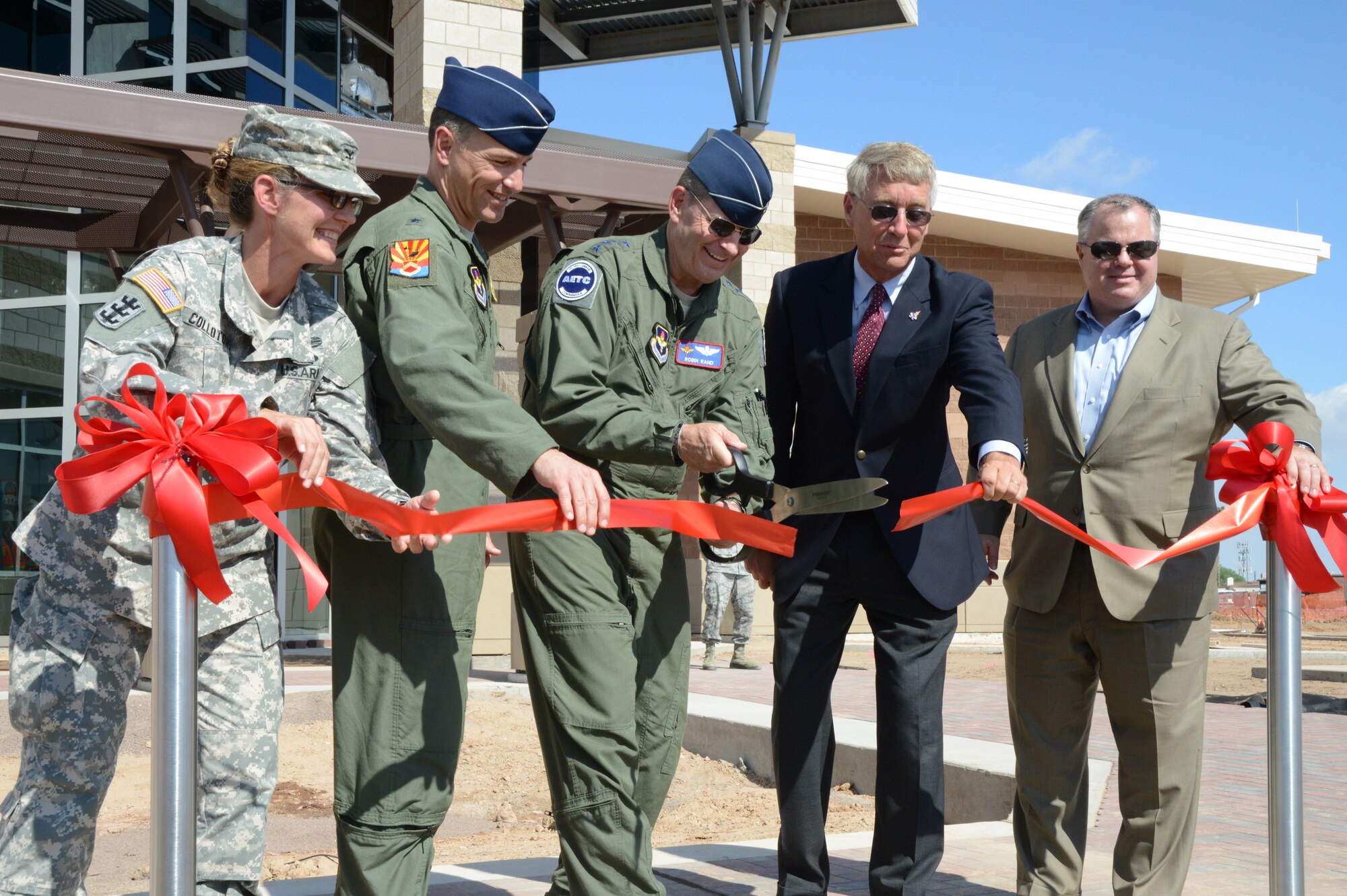 Gen. Robin Rand, Air Education and Training Command commander, cuts the ceremonial ribbon Oct. 9 marking the completion of the academic training center building at Luke Air Force Base. The building is to be used for F-35 Lightning II joint strike fighter pilot training. The ribbon cutting included representatives from the Army Corps of Engineers, 56th Fighter Wing, AETC, Lockheed Martin and the Walsh Group. The facility began receiving furniture, phones and computers Monday. (U.S. Air Force photo/Airman 1st Class James Hensley)