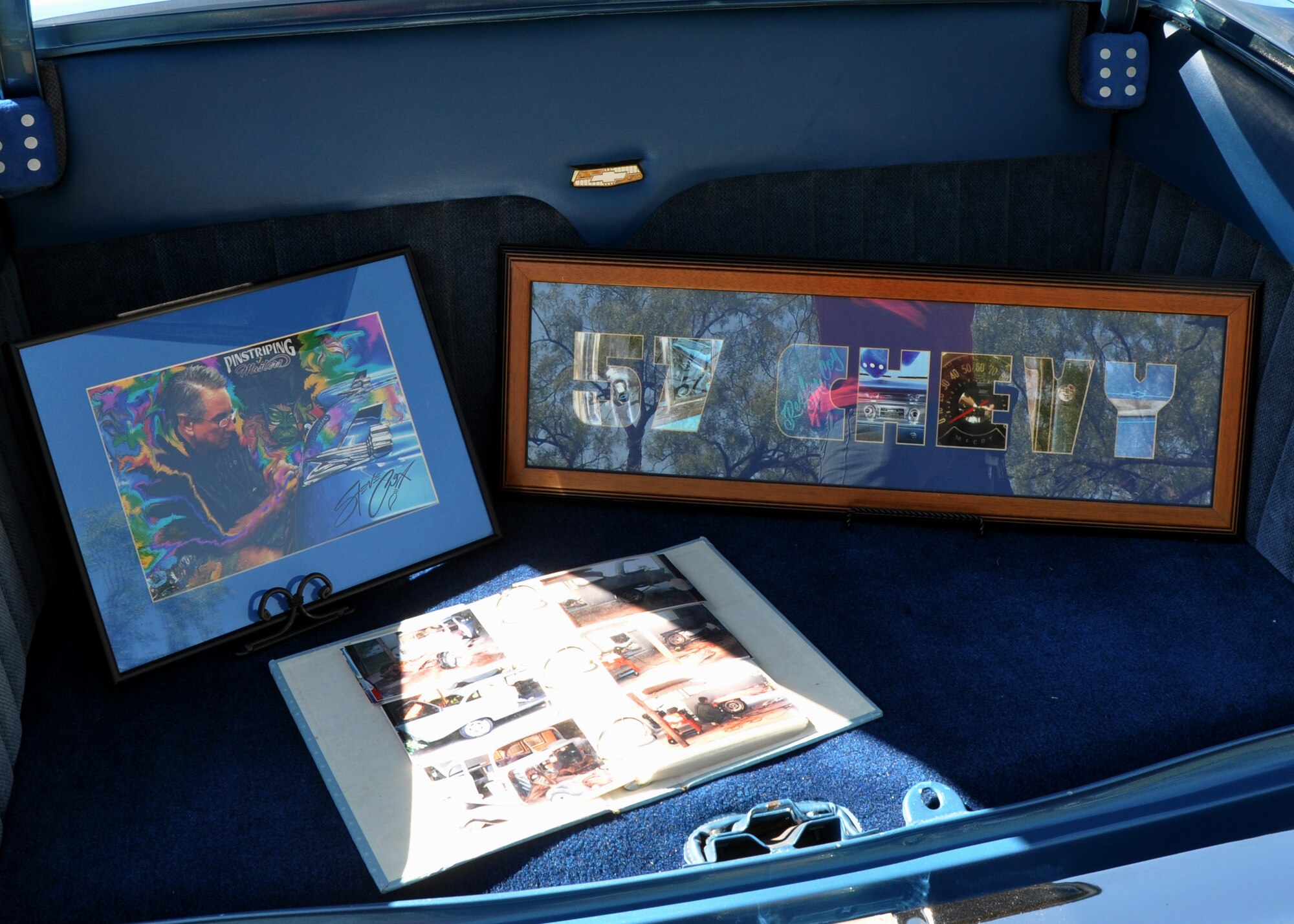 GOODFELLOW AIR FOCE BASE, Texas – Kenneth McCoy, car show competitor, displays images of him working on his 1957 Chevrolet Bel Air during the 16th Annual Goodfellow Recreation Camp Car, Boat and Motorcycle Show Oct. 18. McCoy and several other competitors kept a book of their car’s restoration for spectators to see.  (U.S. Air Force photo/ Senior Airman Joshua Edwards)
