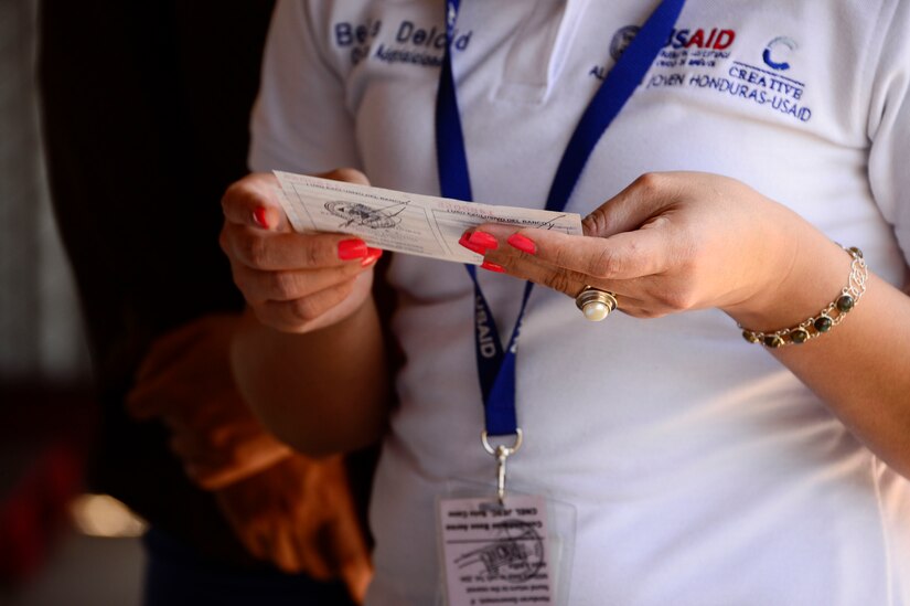 Belkis Delcid, logistics officer with U.S.  Agency for International Development project Youth Alliance Honduras, reviews the vehicle registrations for the four vehicles that were donated to Youth Alliance Honduras by Joint Task Force-Bravo’s Defense Reutilization and Marketing Office on Soto Cano Air Base, Honduras, Oct. 14, 2014. DRMO, the U.S. State Department and the U.S. Agency for International Development worked together to transfer over $100,000 worth of furniture and vehicles to USAID project Youth Alliance Honduras.  DRMO offices receive and screen all property turned in by base agencies for reutilization and reuse. If items cannot be reused within the Department of Defense, it is considered for transfer or donation to other federal or state agencies, or other qualified organizations.  (U.S. Air Force photo /Tech. Sgt. Heather Redman)