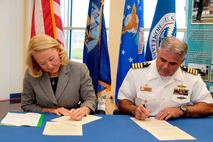 Capt. Timothy Sparks, Joint Base Charleston deputy commander, and Connie Patrick, Federal Law Enforcement Training Centers director, sign an updated usage agreement Oct. 21, 2014, at the No Wake Zone at the FLETC in North Charleston, S.C. The original agreement was with the old Naval Weapons Station and needed to be updated due to joint basing. The usage agreement provides continuing cooperation and co-usage of the five firearm ranges on the Weapons Station. Situated on the site of the former Charleston Naval Base, FLETC is part of the Department of Homeland Security and one of four Federal Law Enforcement Training Centers in the United States, providing training for those who protect the homeland. (U.S. Air Force photo/Eric Sesit)