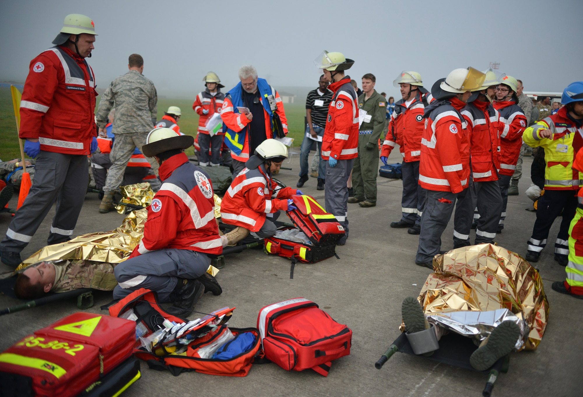 A group of Host Nation medical technicians assist in aiding injured passengers of a simulated aircraft crash during a Major Accident Response Exercise on Ramstein Air Base, Germany, Oct. 18, 2014. Members of the U.S. Air Force and Host Nation agencies partnered in conducting a response and recovery exercise in preparation for possible real-world incidents. (U.S. Air Force photo/Senior Airman Hailey Haux)