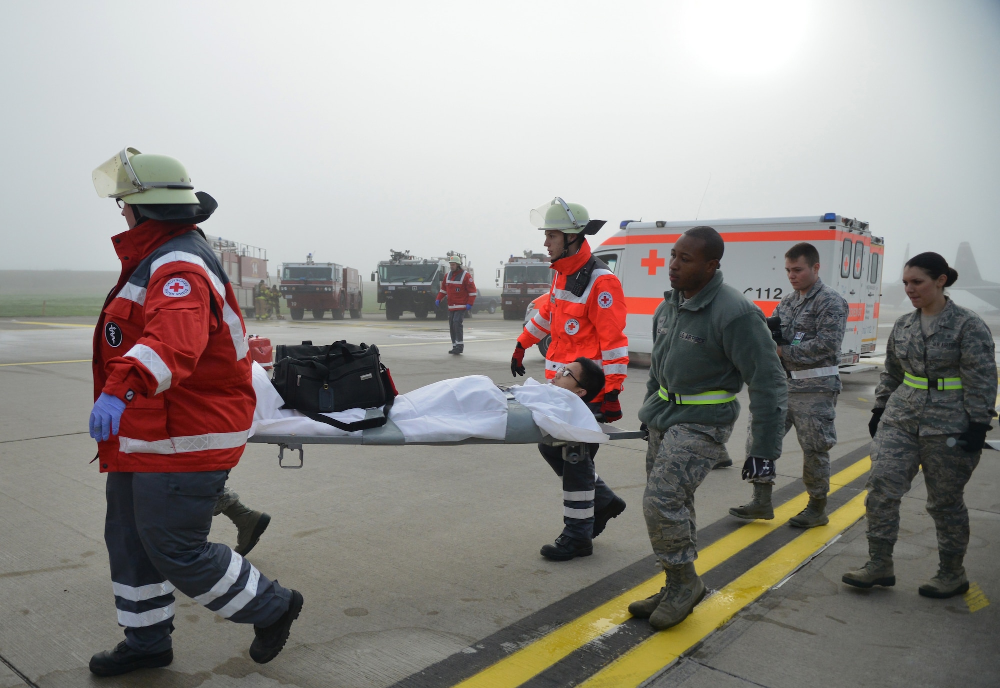 Ramstein Airmen work hand-in-hand with their Host Nation counterparts to load injured passengers into an ambulance after a simulated aircraft crash during a Major Accident Response Exercise on Ramstein Air Base, Germany, Oct. 18, 2014. Members of the U.S. Air Force and Host Nation agencies partnered in conducting a response and recovery exercise in preparation for possible real-world incidents. (U.S. Air Force photo/Senior Airman Hailey Haux)