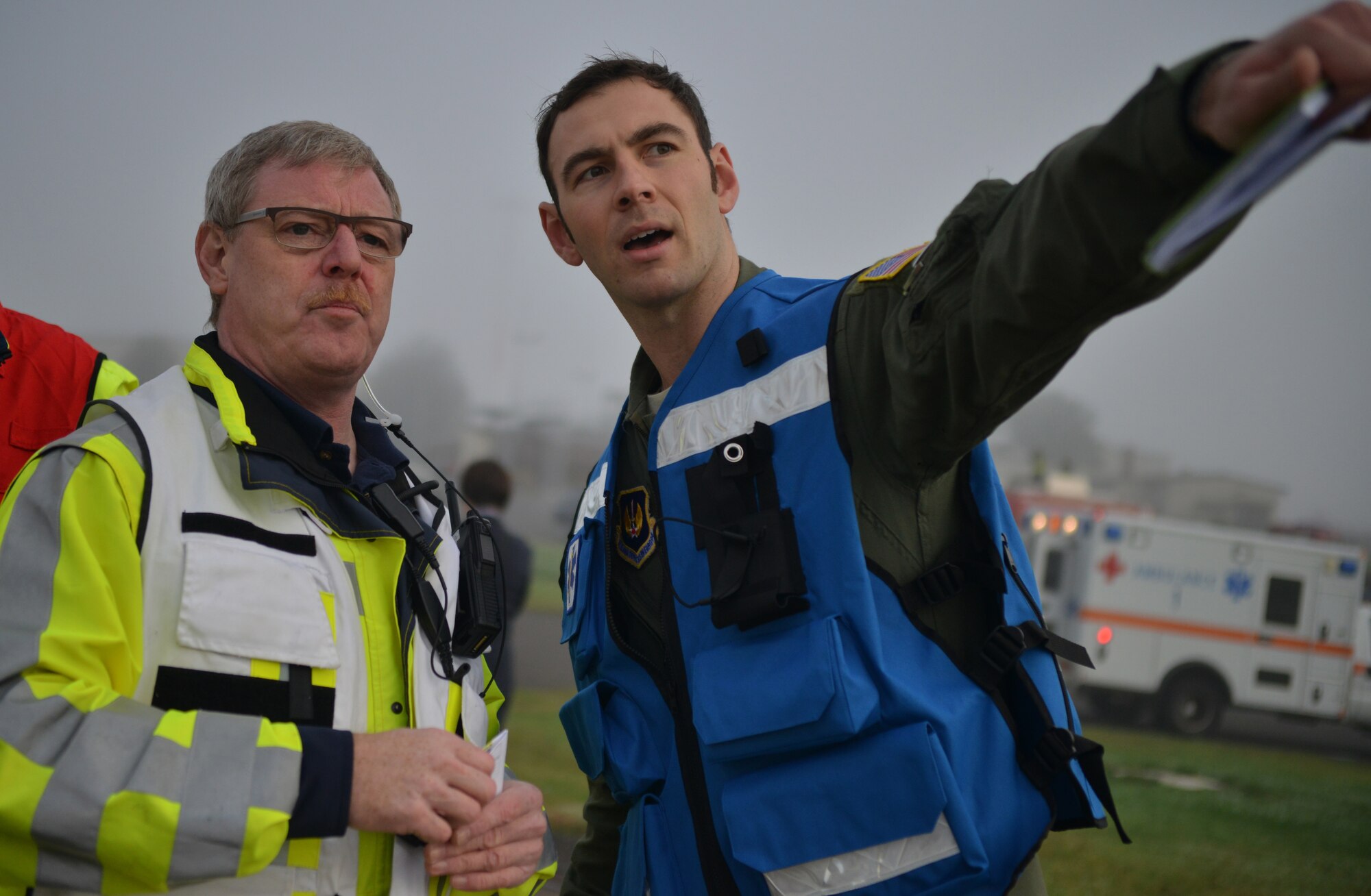 Capt. Michael Damore, 86th Aeromedical Squadron flight surgeon, assists Host Nation personnel by giving instructions on where assets are most needed during a simulated aircraft crash for the Major Accident Response Exercise on Ramstein Air Base, Germany, Oct. 18, 2014. Members of the U.S. Air Force and Host Nation agencies partnered in conducting a response and recovery exercise in preparation for possible real-world incidents. (U.S. Air Force photo/Senior Airman Hailey Haux)