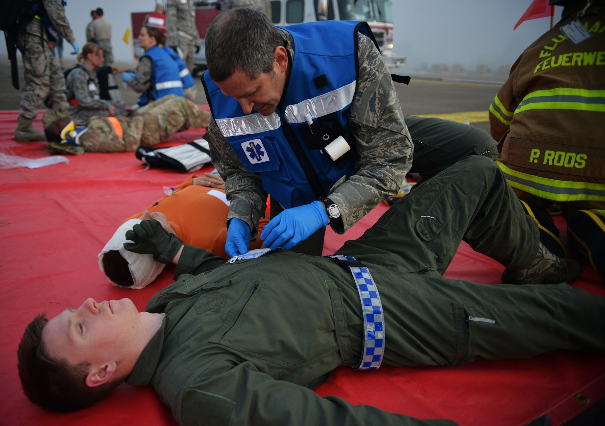 A member of the medical team responds to a simulated aircraft crash and cares for the injured during the Major Accident Response Exercise on Ramstein Air Base, Germany, Oct. 18, 2014. Members of the U.S. Air Force and Host Nation agencies partnered in conducting a response and recovery exercise in preparation for possible real-world incidents. (U.S. Air Force photo/Senior Airman Hailey Haux)
