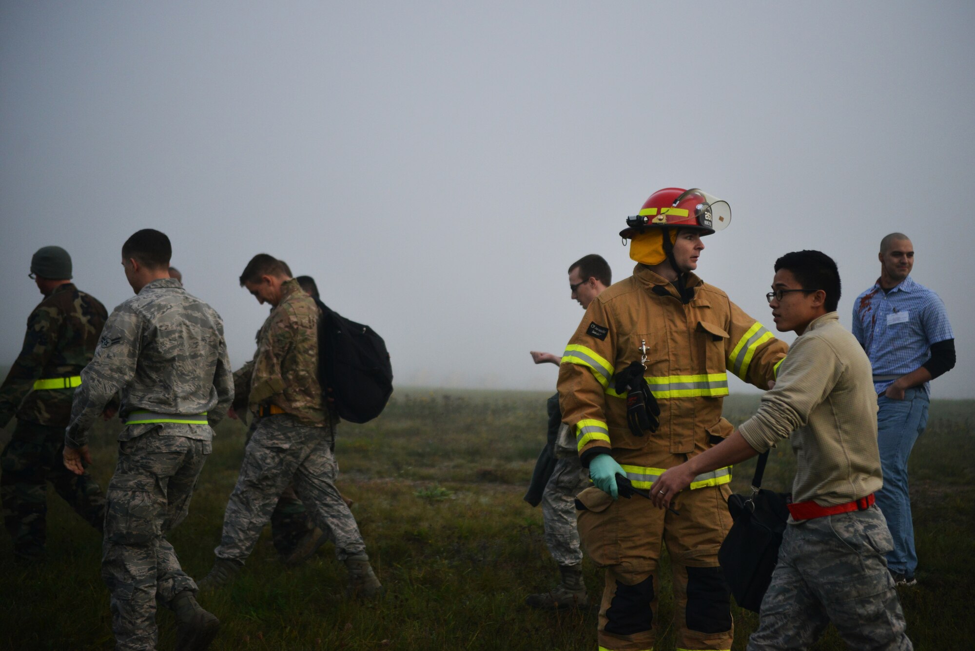 Firefighters usher victims away from the simulated aircraft crash during the   Major Accident Response Exercise on Ramstein Air Base, Germany, Oct. 18, 2014. Members of the U.S. Air Force and Host Nation agencies partnered in conducting a response and recovery exercise in preparation for possible real-world incidents. (U.S. Air Force photo/Senior Airman Hailey Haux)