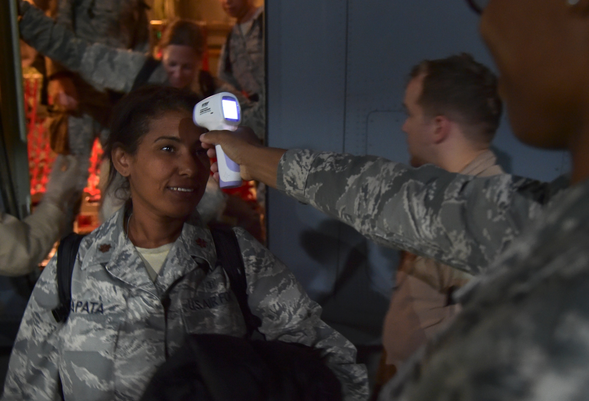 Maj. Mayra Zapata, 633rd Medical Operations Squadron, gets her temperature taken by Tech. Sgt. Saquadrea Crosby, 86th Aerospace Medicine Squadron public health NCOIC, as she deplanes a C-130J Super Hercules at Ramstein Air Base, Germany, Oct. 19, 2014. Any personnel traveling into Ramstein from Ebola infected areas will be medically screened upon their arrival and cleared by public health for onward travel to ensure the health and safety of all passengers, aircrew and members of the Kaiserslautern community. (U.S. Air Force photo/Staff Sgt. Sara Keller)