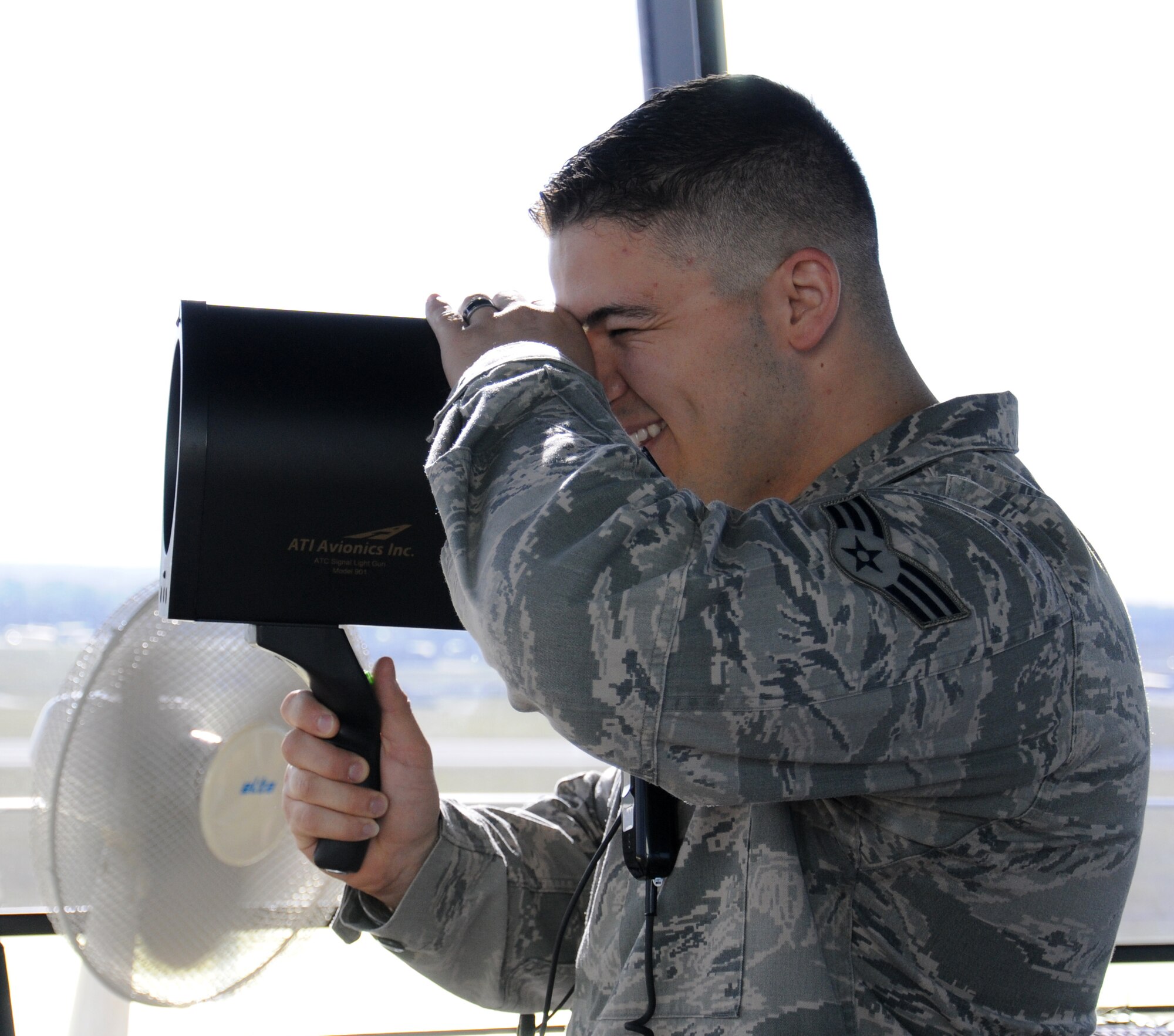 U.S. Air Force Senior Airman Andrew Kalina, 100th Operations Support Squadron Air Traffic Controller from Hoffman Estates, Ill., demonstrates the use of a light gun signal (a backup when radio communications are unavailable) Oct. 3, 2014, on RAF Mildenhall, England. As a tower controller, Kalina and his team control five miles of airspace surrounding the base. (U.S. Air Force photo/Gina Randall/Released)