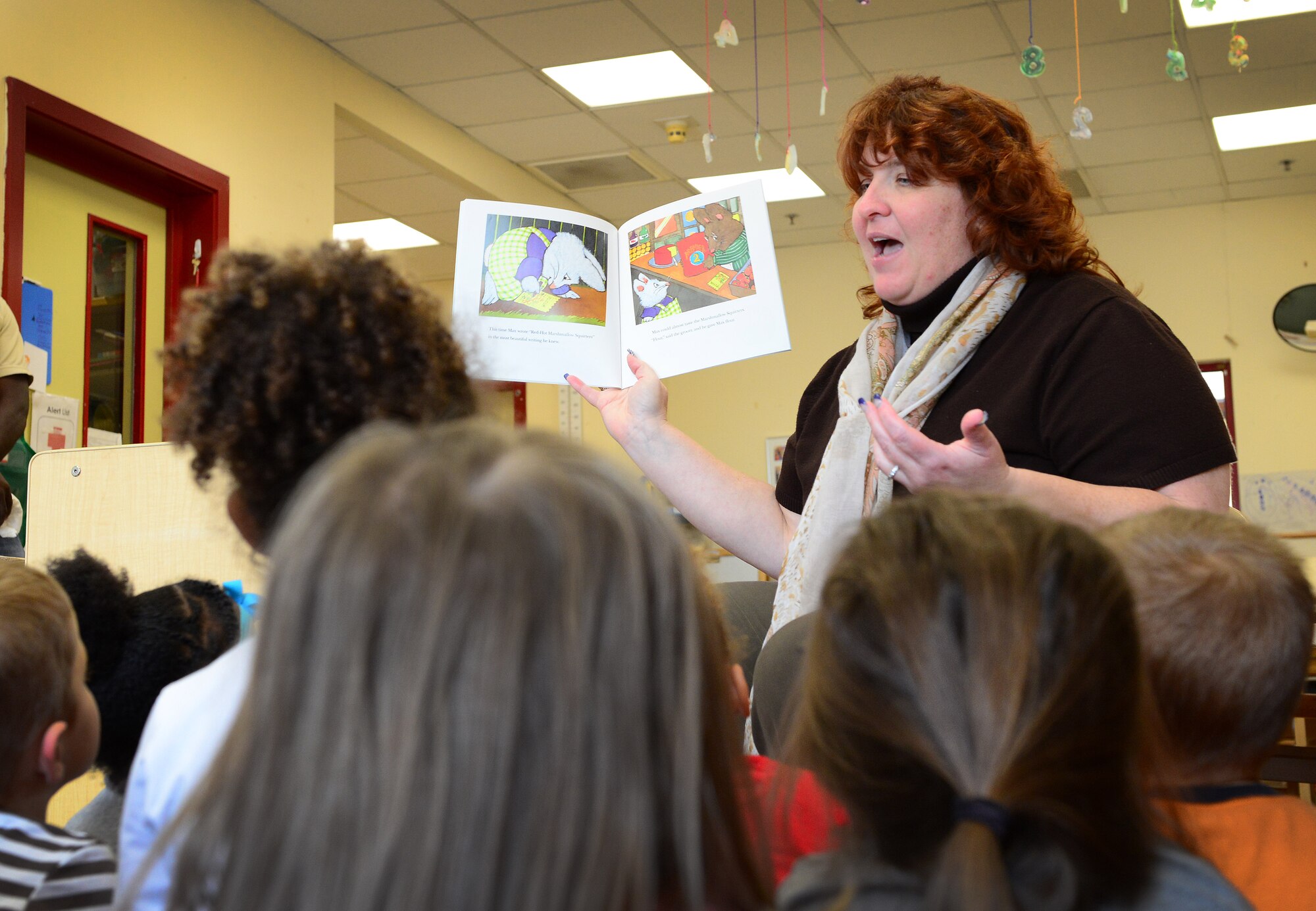 Katherine Savage, 31st Force Support Squadron flight chief, reads to children at the Child Development Center during a “Read for the Record” pledge, Oct. 21, 2014, at Aviano Air Base, Italy. Last year the pledge read to 2,462,860 children, supporting the Jumpstart’s mission and to be the world’s largest shared reading experience. (U.S. Air Force photo/Senior Airman Matthew Lotz)