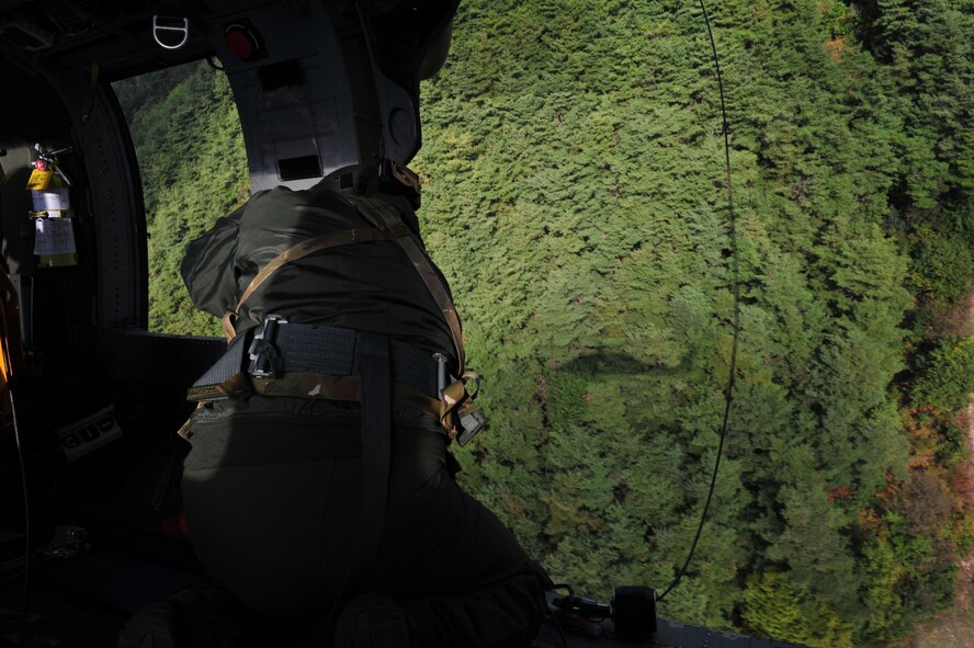 U. S. Air Force Staff Sgt. Jesus Garcia, a 33rd Rescue Squadron special mission aviator, prepares to pick up a simulated survivor, Osan Air Base, Republic of Korea, Oct. 15, 2014. The 33rd RQS started conducting combat search and rescue task force training Oct. 13. (U.S. Air Force photo by Staff Sgt. Rachelle Coleman/Released)