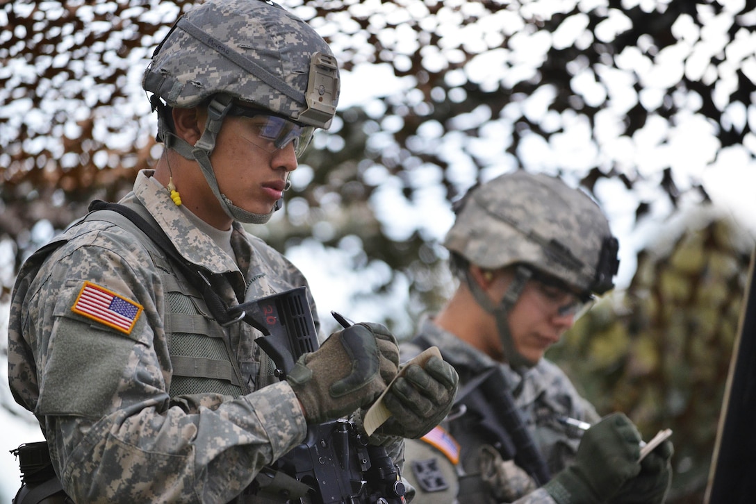 U.S. Army Pvt. Christian Moreno, left, takes notes during the 2nd Cavalry Regiment Expert Infantryman Badge qualification on the Joint Multinational Training Command’s Grafenwoehr Training Area, Germany, Oct. 21, 2014. The Expert Infantryman Badge is presented to soldiers who complete a course of testing designed to demonstrate proficiency in a range of infantry skills.