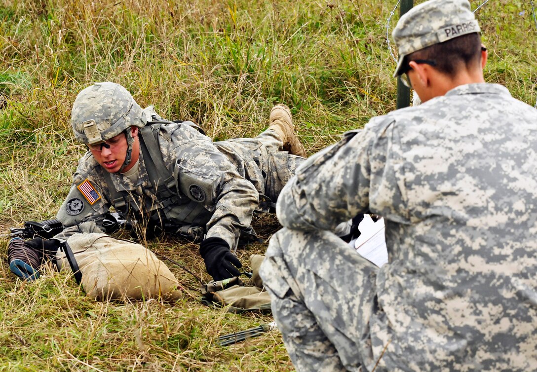 A U.S. soldier, left, completes tests of basic warrior tactics during Expert Infantryman Badge qualification on the Joint Multinational Training Command's Grafenwoehr Training Area, Germany, Oct. 21, 2014. The soldier is assigned to the 2nd Cavalry Regiment.
