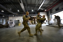 (From left) U.S. Air Force Airman 1st Class Jon Peterson, 455th Expeditionary Aerial Port Squadron aerial porter, and Senior Airman Cameron Corricelli, 455 EAPS aerial porter, participate in Check Six program instruction at Bagram Airfield, Afghanistan Oct. 21, 2014.  The program is designed to increase military members’ awareness and practice muscle memory that will become critical in the event of an attack or violent occurrence.  Peterson is deployed from Travis Air Force Base, Calif. and a native of Fairbanks, Alaska. Corricelli is deployed from Charleston Air Force Base, South Carolina and a native of Nashua New Hampshire.  (U.S. Air Force photo by Staff Sgt. Evelyn Chavez/Released)