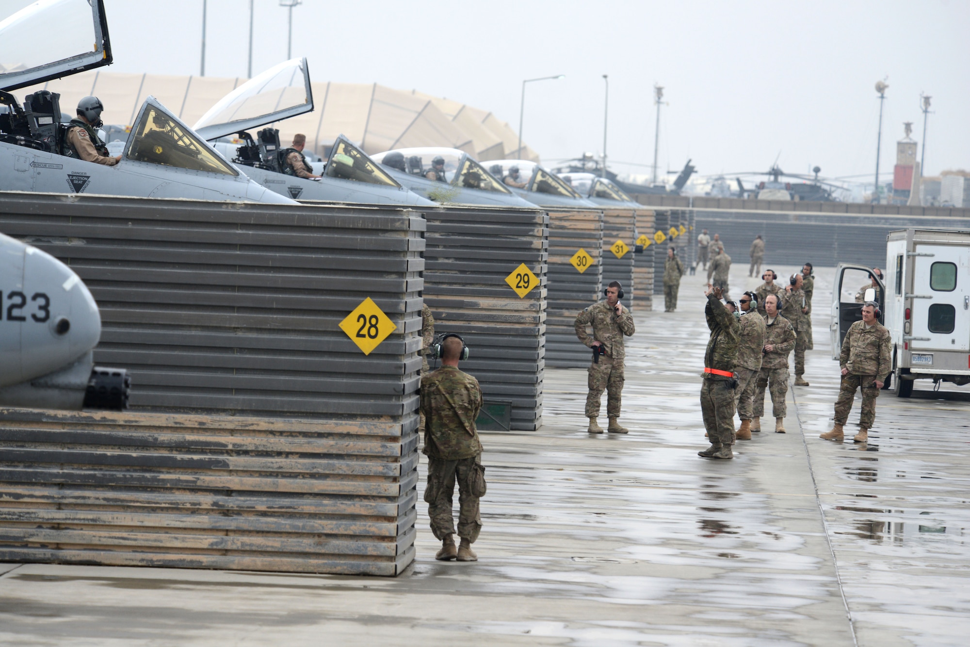 BAGRAM AIRFIELD, Afghanistan -  U.S. Air Force A-10 Thunderbolt II pilots assigned to the 303rd Expeditionary Fighter Squadron wait for maintainers assigned to the 455th Expeditionary Maintenance Squadron to give them the okay to taxi onto the runway and depart Bagram Airfield, Afghanistan Oct. 19, 2014. The 303 EFS was responsible for close air support operations throughout Afghanistan and was deployed from the 442nd Fighter Wing at Whiteman Air Force Base, Mo. The 303 EFS was succeeded by the 163rd Expeditionary Fighter Squadron.   (U.S. Air Force photo by Master Sgt. Cohen A. Young/Released)