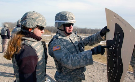 A range safety from the Indiana National Guard shows
Julia Schoenfeld her results after she fired an M-9 pistol. Schoenfeld is
with the Civilian Expeditionary Workforce, a workforce of Department of
Defense civilians trained and equipped to deploy oversees in support of
worldwide military missions. The very first iteration of the CEW graduated
from the Camp Atterbury, Ind., training site Feb. 3, 2010.