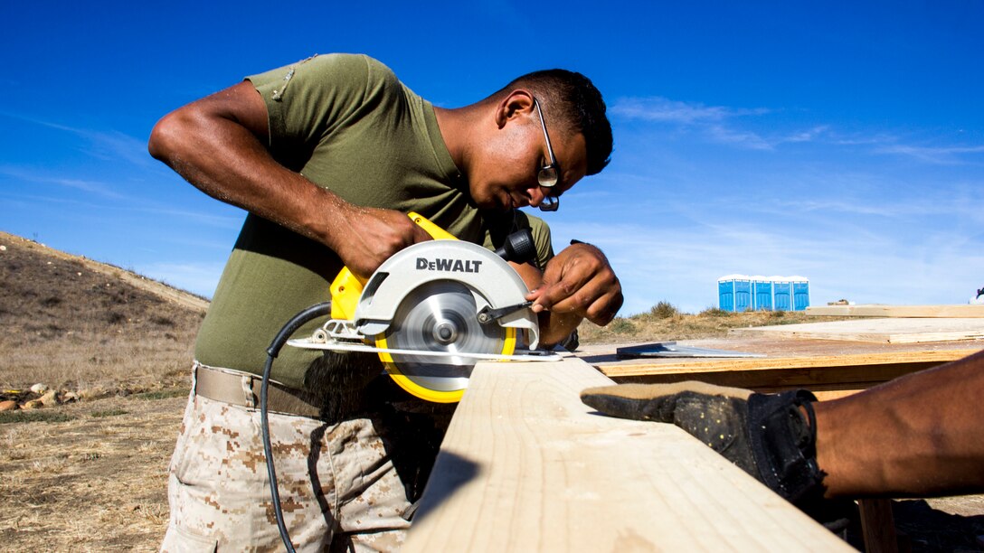 Lance Cpl. Reyaz Rasul, 18, a combat engineer with Marine Wing Support Squadron 373, Combat Engineer Platoon, from Ocoee, Fla., cuts a piece a of 4-inch by 2-inch wooden board to erect a multipurpose building (SWA hut) during exercise Pacific Horizon 2015 aboard Marine Corps Base Camp Pendleton, Calif., Oct. 21. The SWA hut would serve as shelter, billeting or medical facility in a humanitarian aid or disaster relief mission. PH 15 is a scenario driven, simulation supported crisis response exercise designed to improve 1st Marine Expeditionary Brigade's and Expeditionary Strike Group 3's interoperability and strengthen Navy-Marine Corps relations by conducting an in-stream Maritime Prepositioning Force offload of equipment by providing host country civil-military security assistance, and by conducting infrastructure restoration support from Oct. 20-28. 