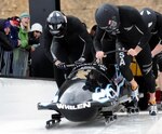 In this file photo, bobsled pilot Sgt. Mike Kohn (front right) of the Virginia National Guard, leads his four-man squad at the start of a U.S. World Cup Team Trials race in 2009. Each of the three U.S. bobsled teams are piloted by former or current National Guard members.