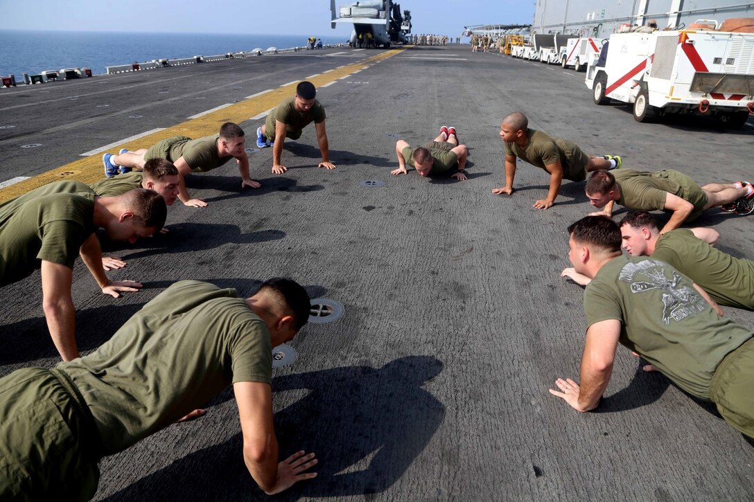 Marines with Charlie Battery, Battalion Landing Team 2nd Battalion, 1st Marines, 11th Marine Expeditionary Unit (MEU), conduct a group physical training session aboard the amphibious assault ship USS Makin Island (LHD 8), Oct. 19. The Makin Island Amphibious Ready Group (ARG) and the embarked 11th MEU are deployed in support of maritime security operations and theater security cooperation efforts in the U.S. 5th Fleet area of responsibility. (U.S. Marine Corps photos by Cpl. Demetrius Morgan/ Released)  