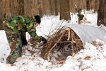 Members of the Norwegian Home Guard youth learn how to build temporary shelters as part of cold weather field exercises taught during the Norwegian exchange program at Camp Ripley, Minn., on Feb. 15, 2010.