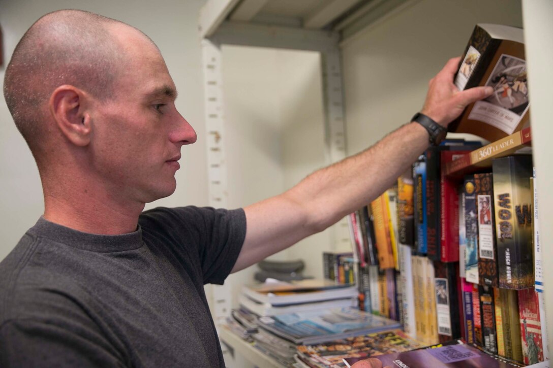 Lance Cpl. Vincent D. Thomson, from Wilmington, Vermont, organizes donated books Oct. 17 at the Swap Shop on Camp Hansen. Thomson implemented the Swap Shop as a simple way to donate and distribute used items at no cost. Thomson is a ground radio repairer with 7th Communication Battalion, III Marine Expeditionary Force Headquarters Group, III MEF. 